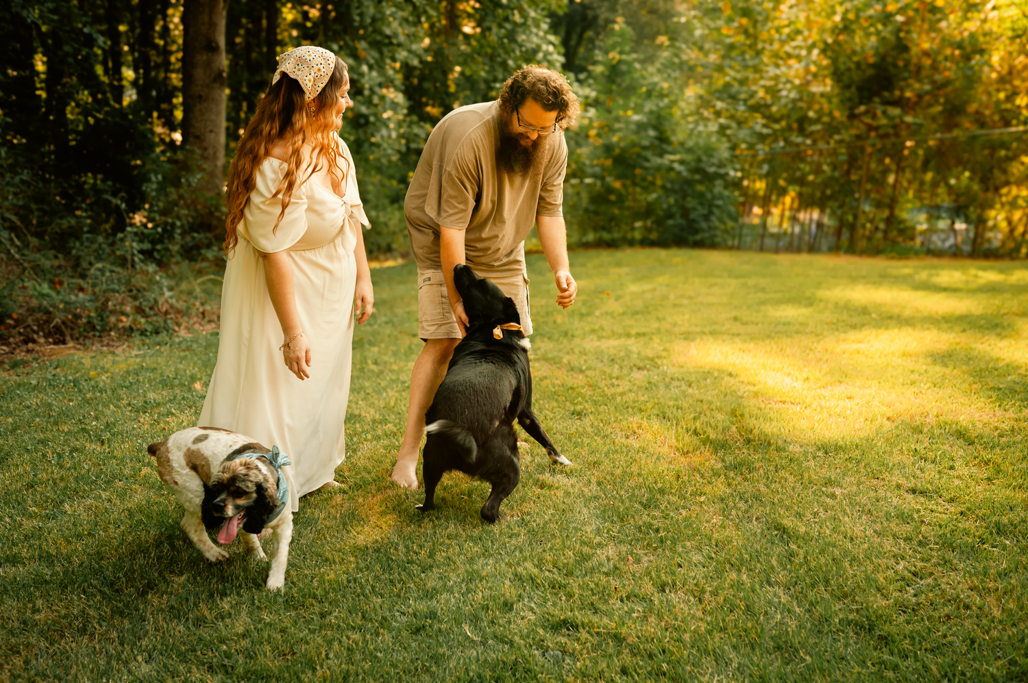 Mom and dad playing in the yard with dogs for family photos in Cartersville, GA.