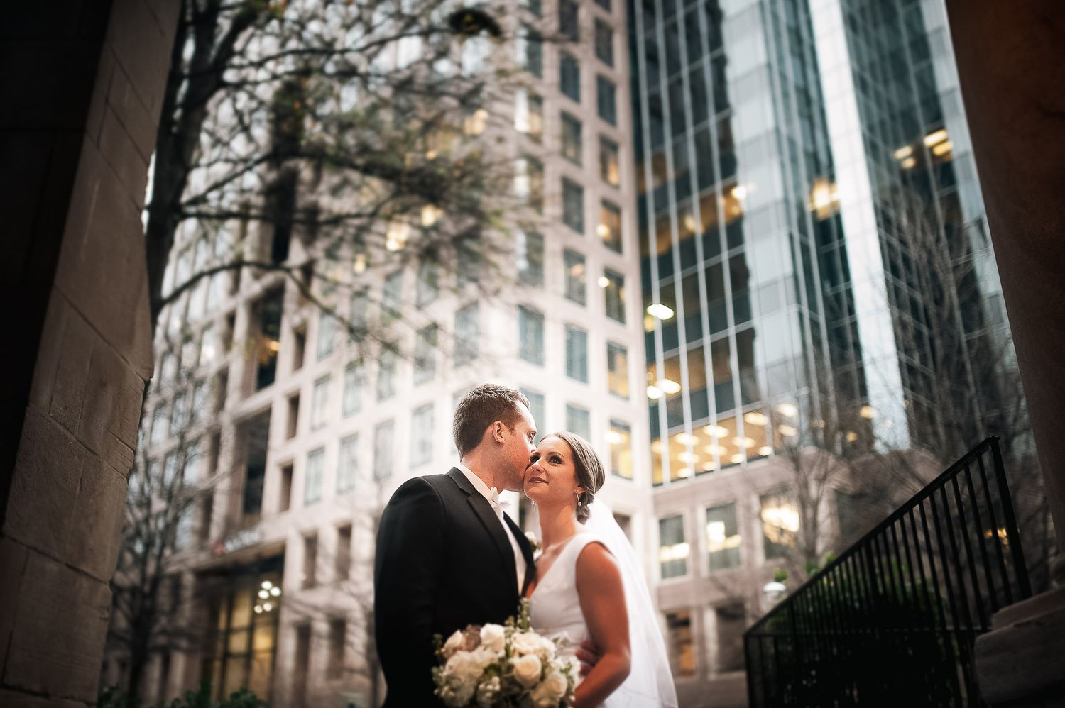 Bride and groom formal portraits during winter wedding in front of skyscrapers at Wimbish House in Atlanta, GA.