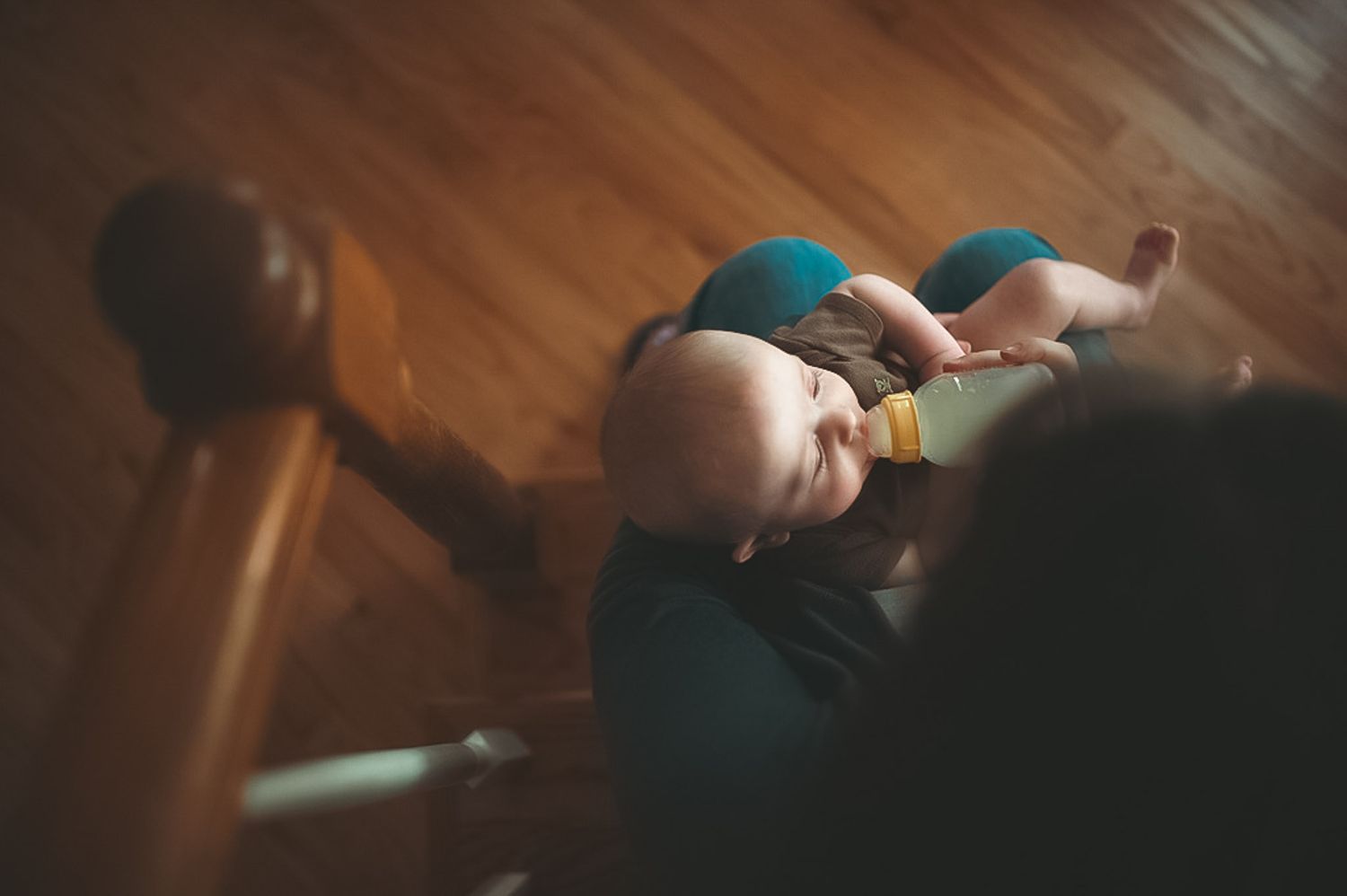 Mom bottle feeding baby in lifestyle newborn session in Dallas, GA.
