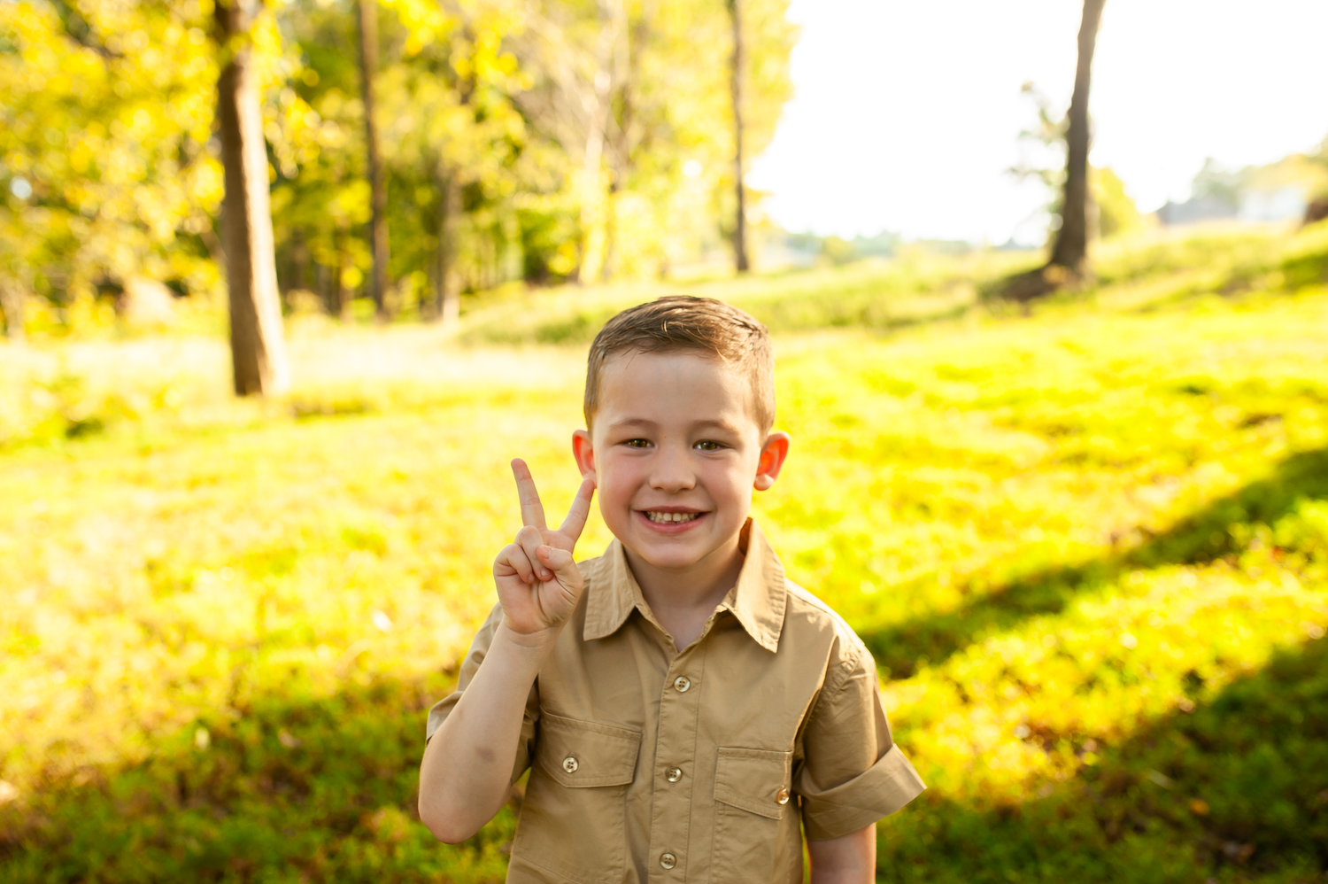 Boy being silly with peace sign in personality child portrait during family session in Cartersville, GA.