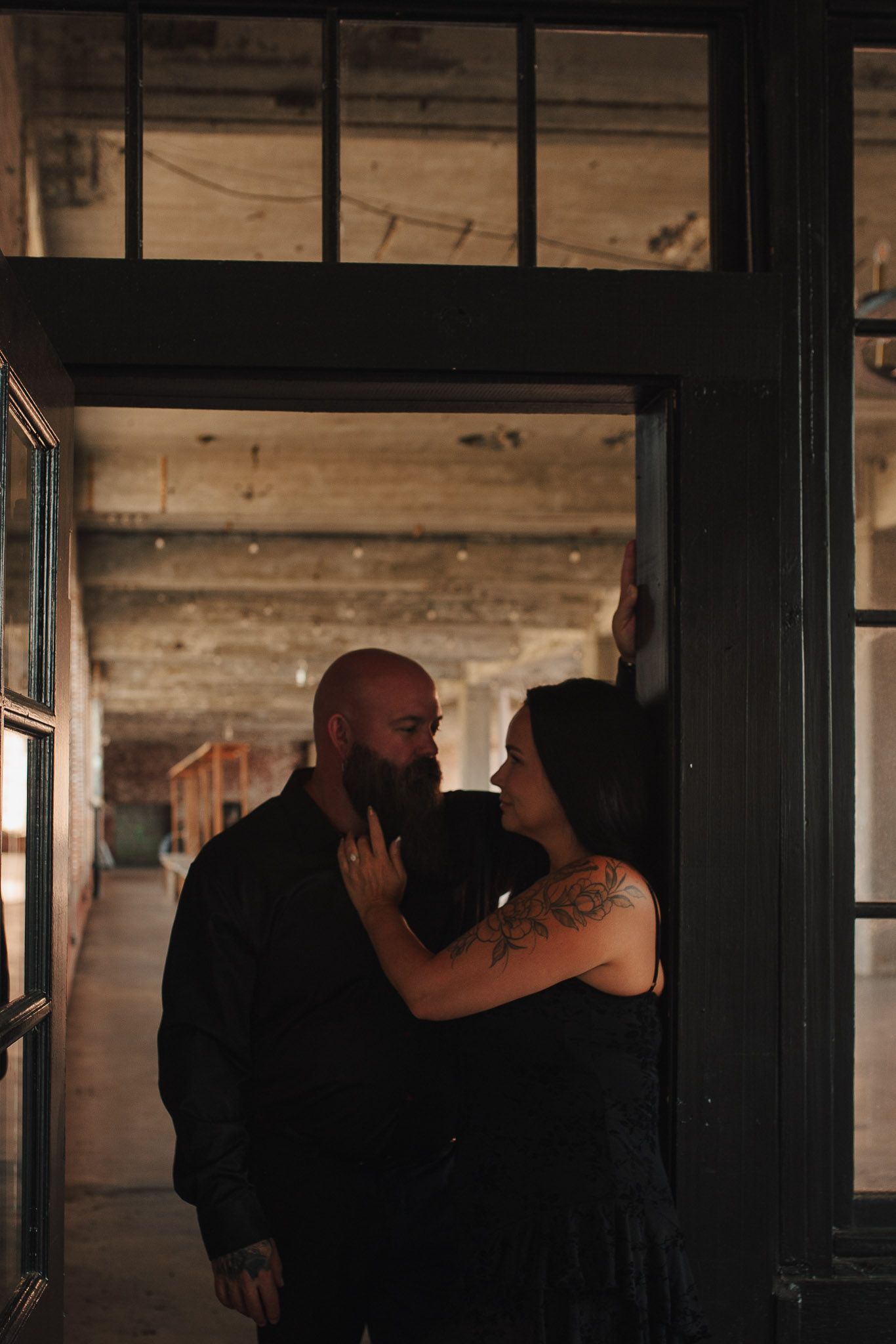 Intimate moment of couple in doorway at Lindale Mill engagement sesssion outside Rome, GA.