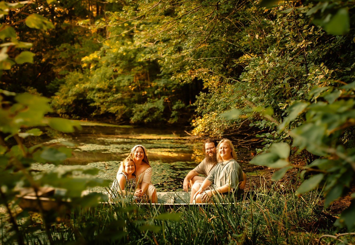 Family posing in a boat at their house for family photos in Cartersville, GA.