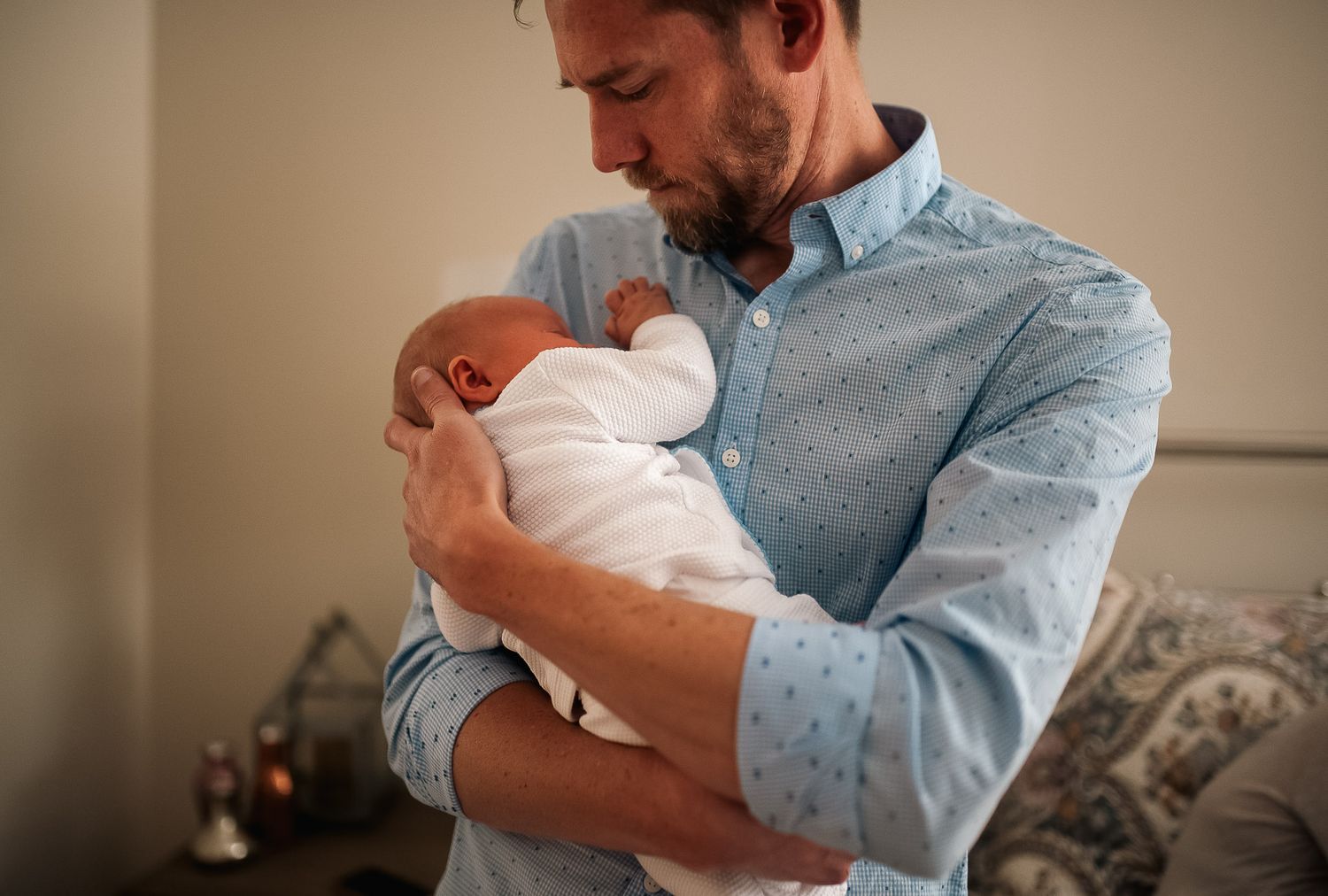 Dad holding baby in at home newborn session in Marietta, GA.