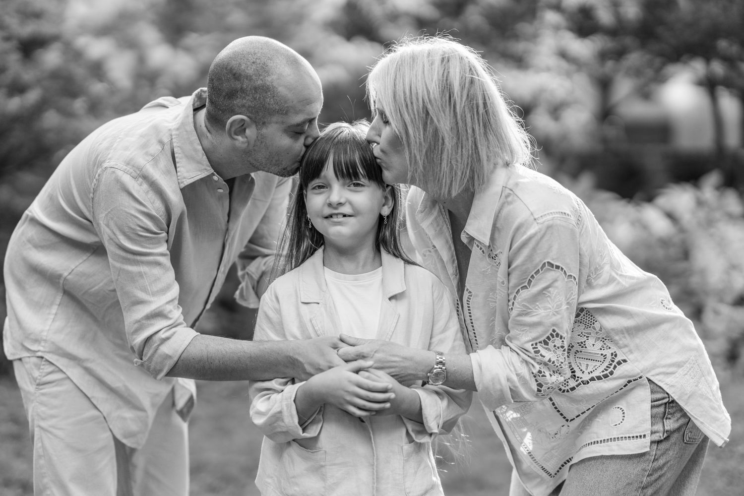 Black and white family portrait series showing intimate moments outdoors.