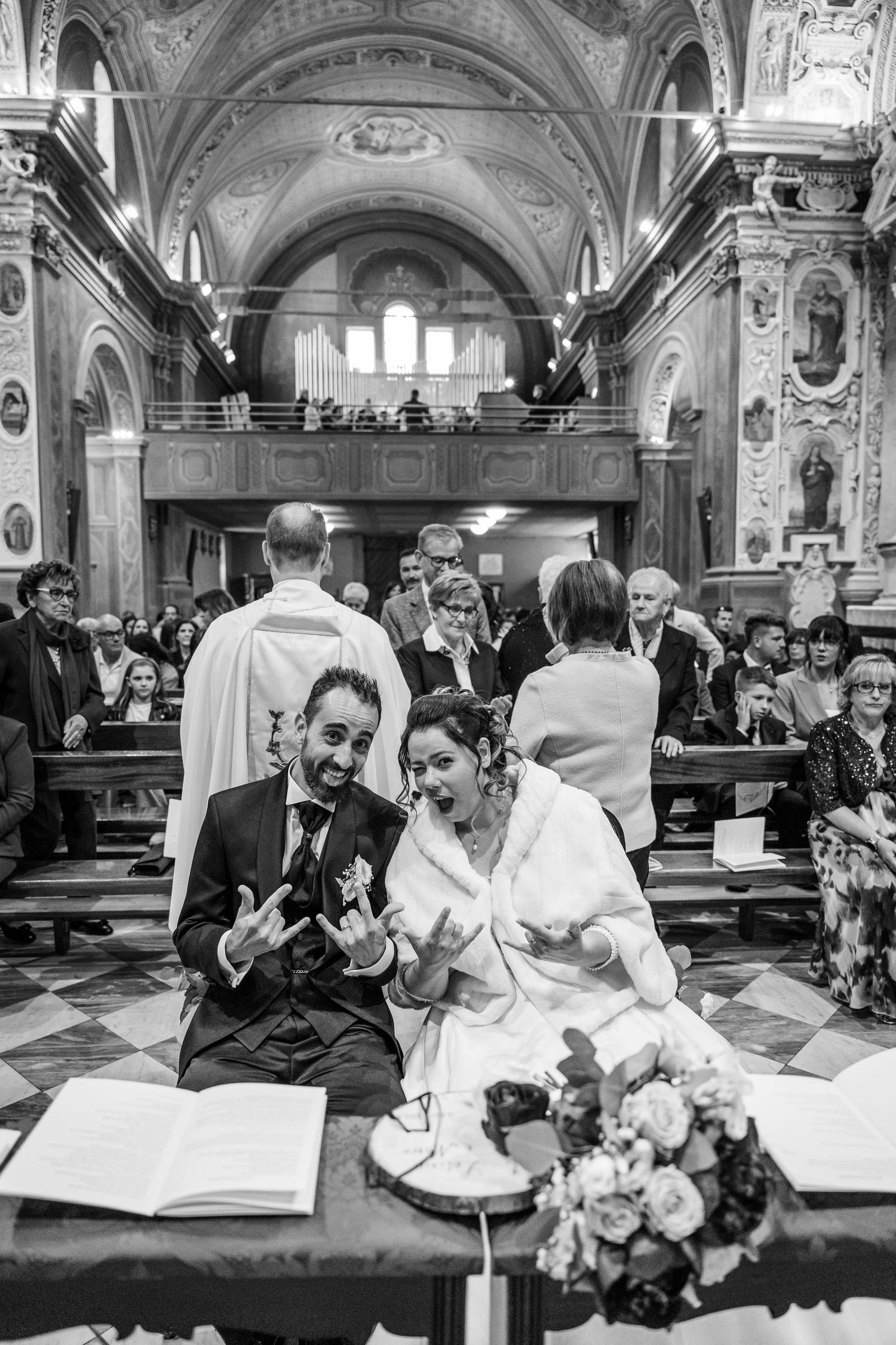 Black and white wedding ceremony photos show intimate moments in an ornate church setting.