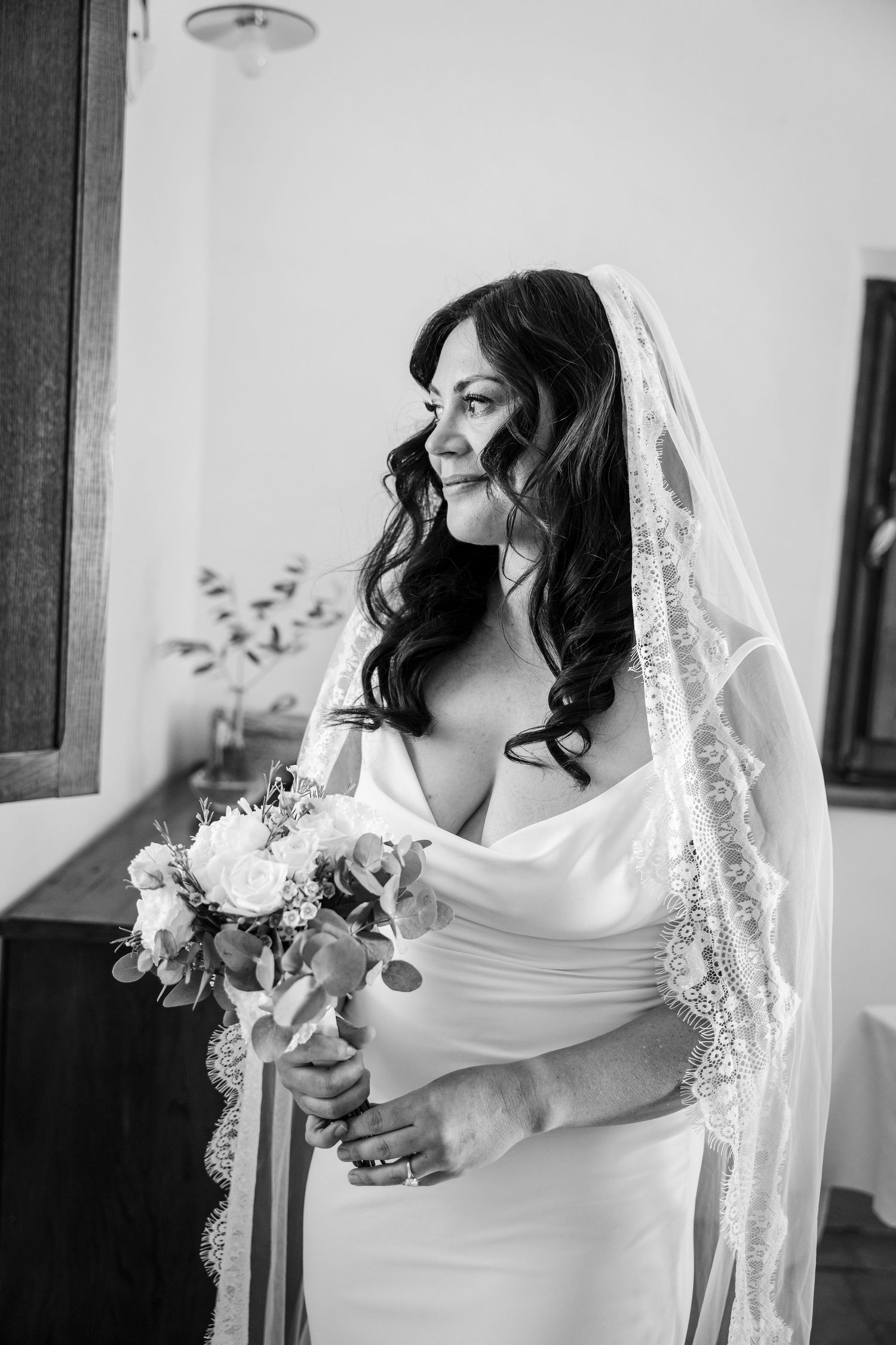 A series of black and white bridal portraits showing elegant poses with a flowing veil and white bouquet.