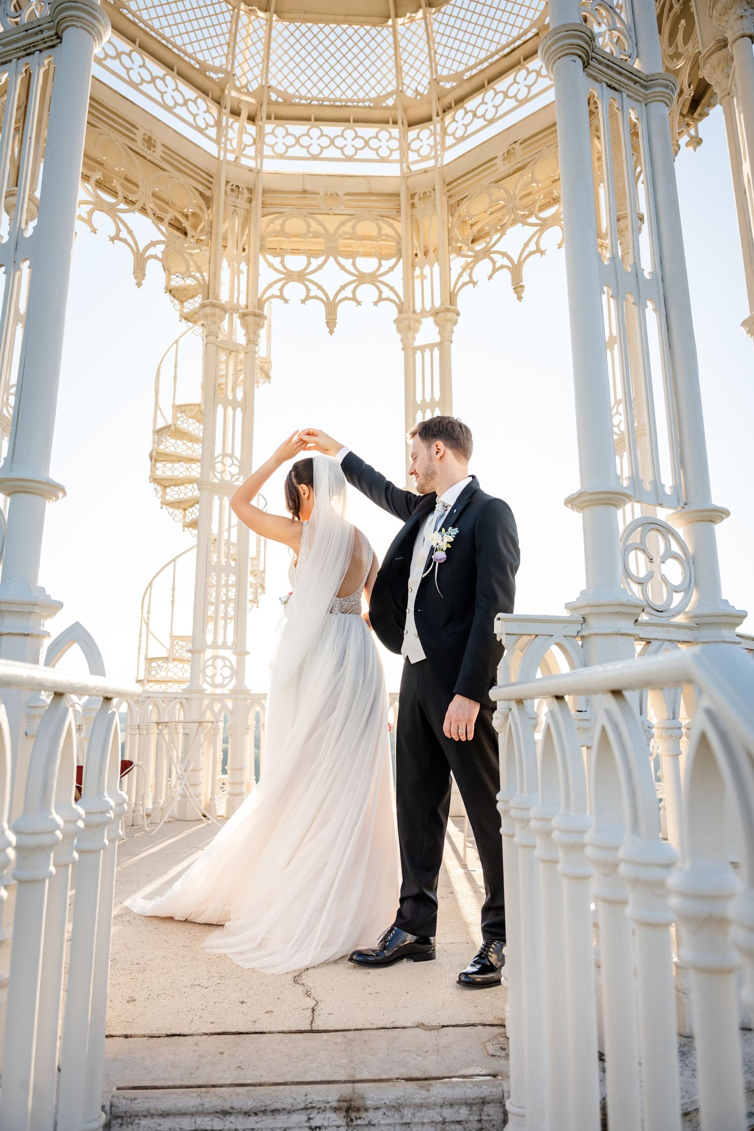 Bride and groom dancing in an elegant white Victorian gazebo on their wedding day.