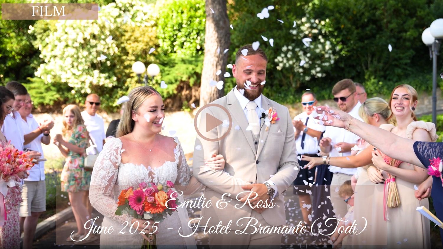 Wedding guests celebrate and dance together at an outdoor garden reception on a sunny summer day.