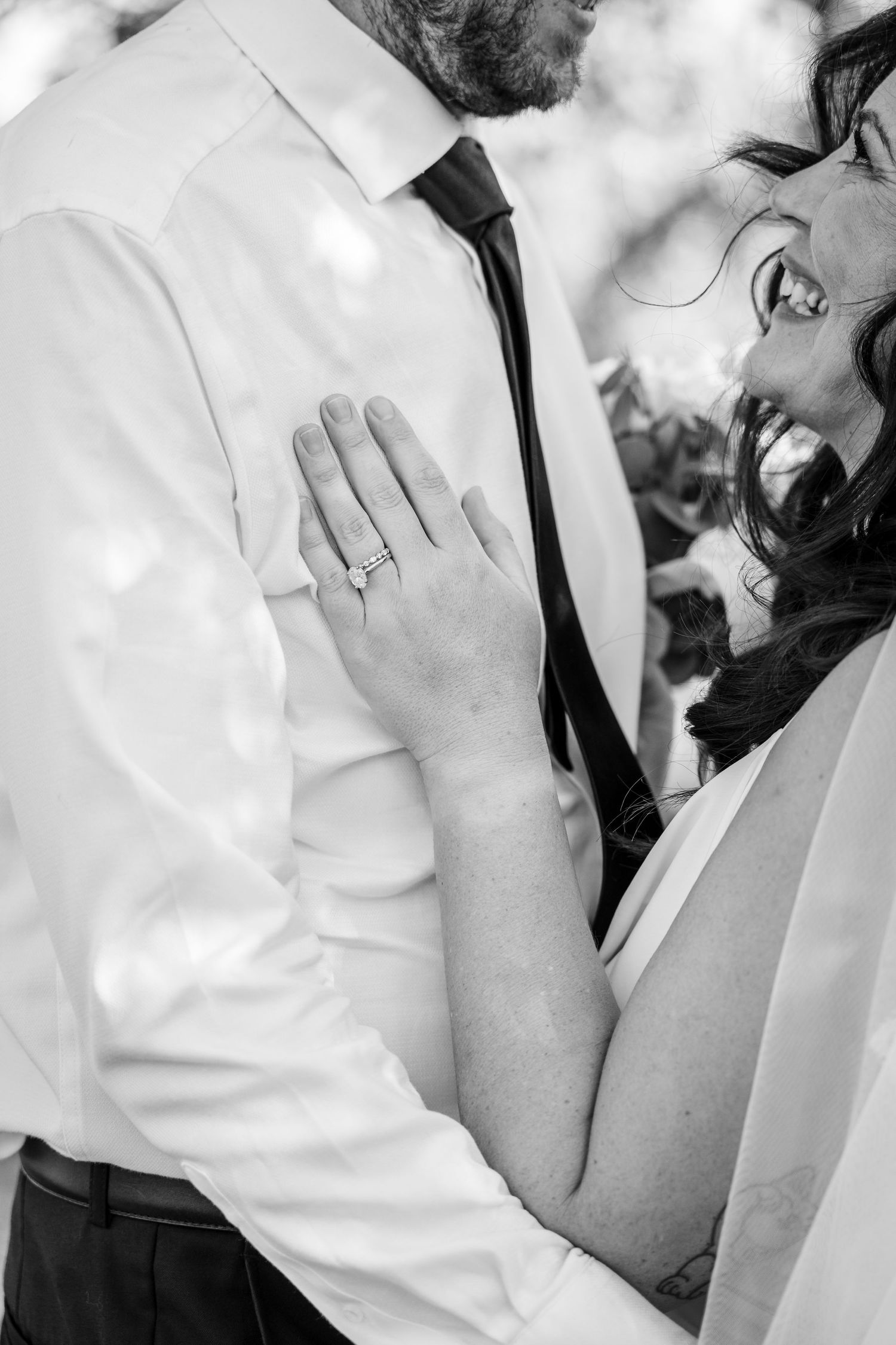 Black and white close-up of a wedding ring and intimate moment between newlyweds.