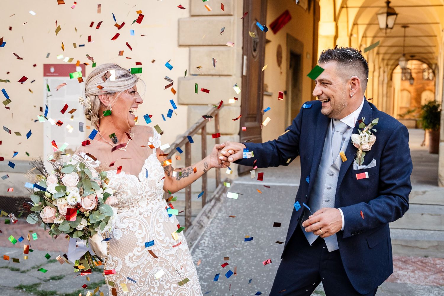 Newlywed couple celebrates with confetti flying in the air during their joyful wedding ceremony exit.