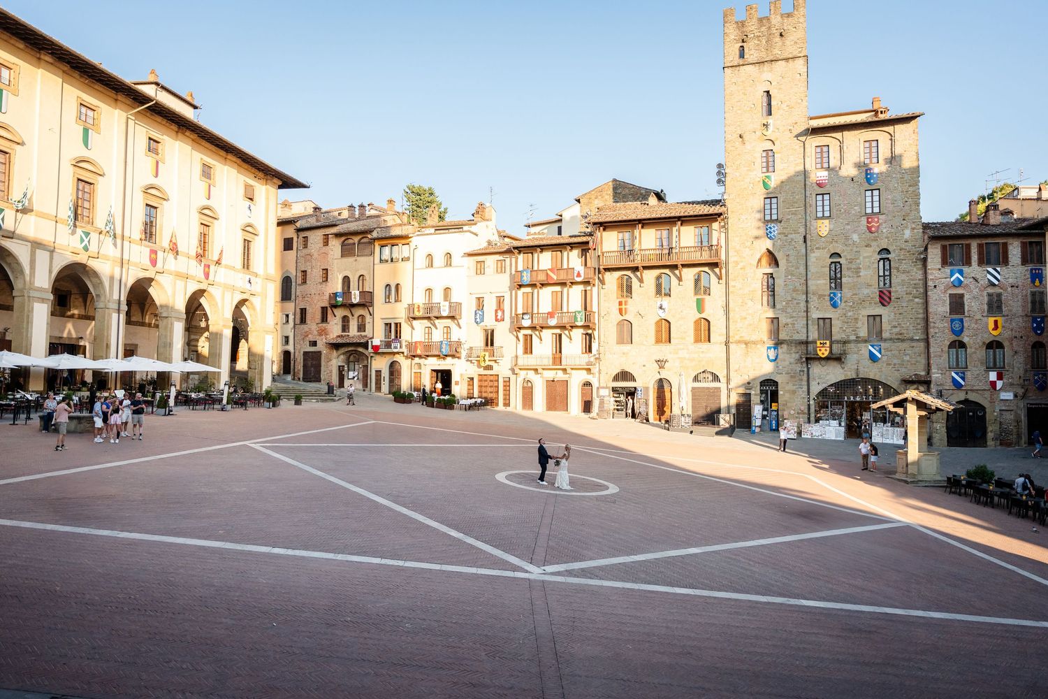 Panoramic view of the historic Piazza Grande in Arezzo, Italy with medieval buildings and arched architecture.