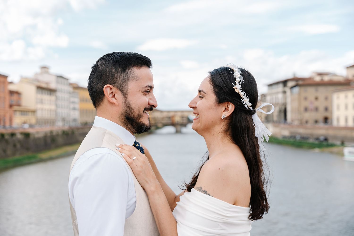 Couple shares romantic moments along the waterfront during a destination wedding photoshoot in Florence, Italy.