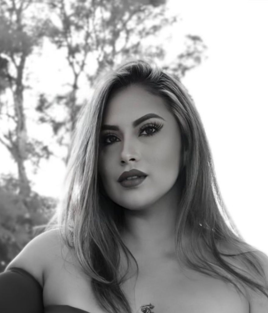A black and white portrait showing long hair and dramatic makeup against a soft background.