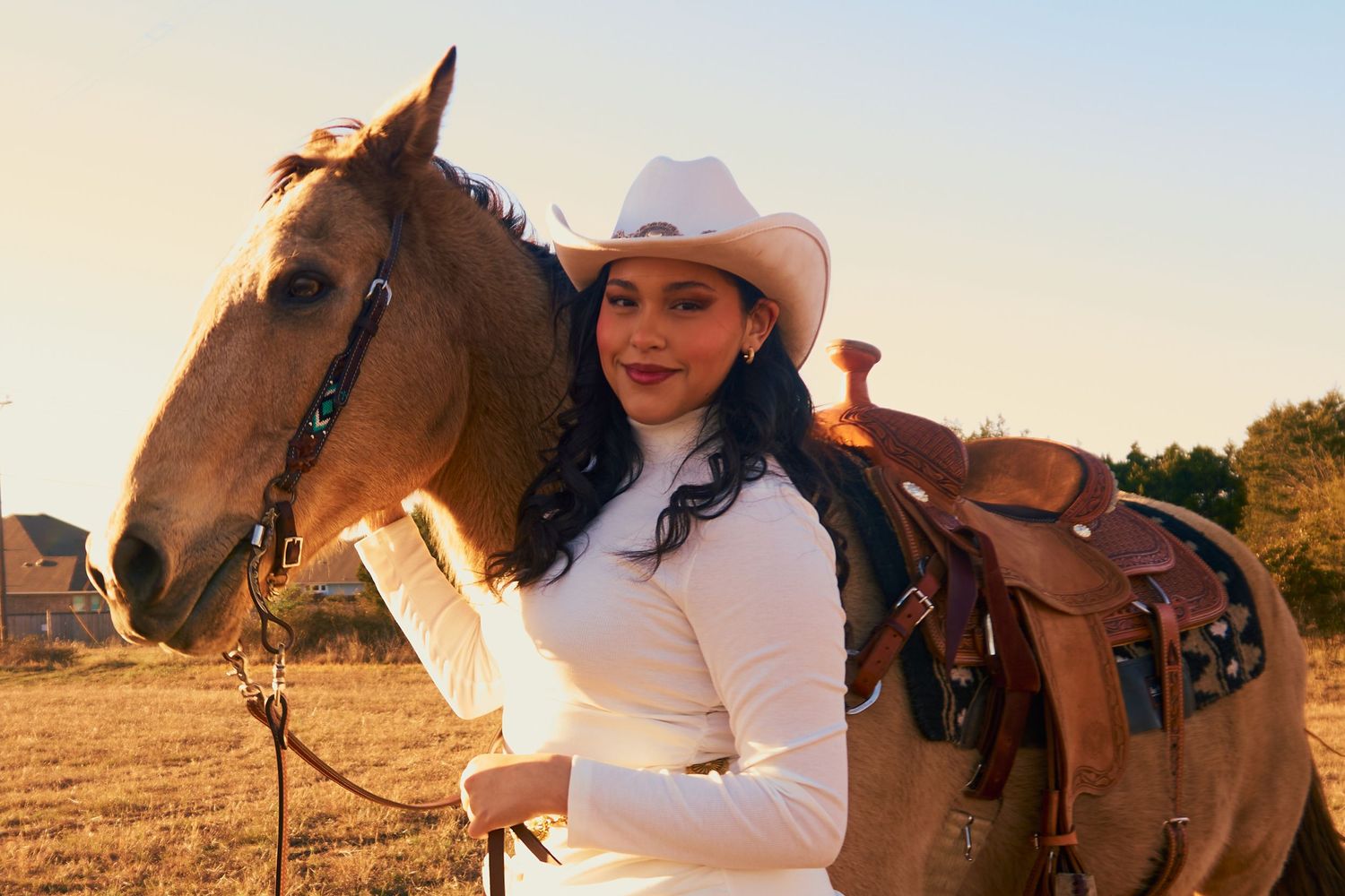 Equestrian portrait with brown horse wearing western saddle at sunset.