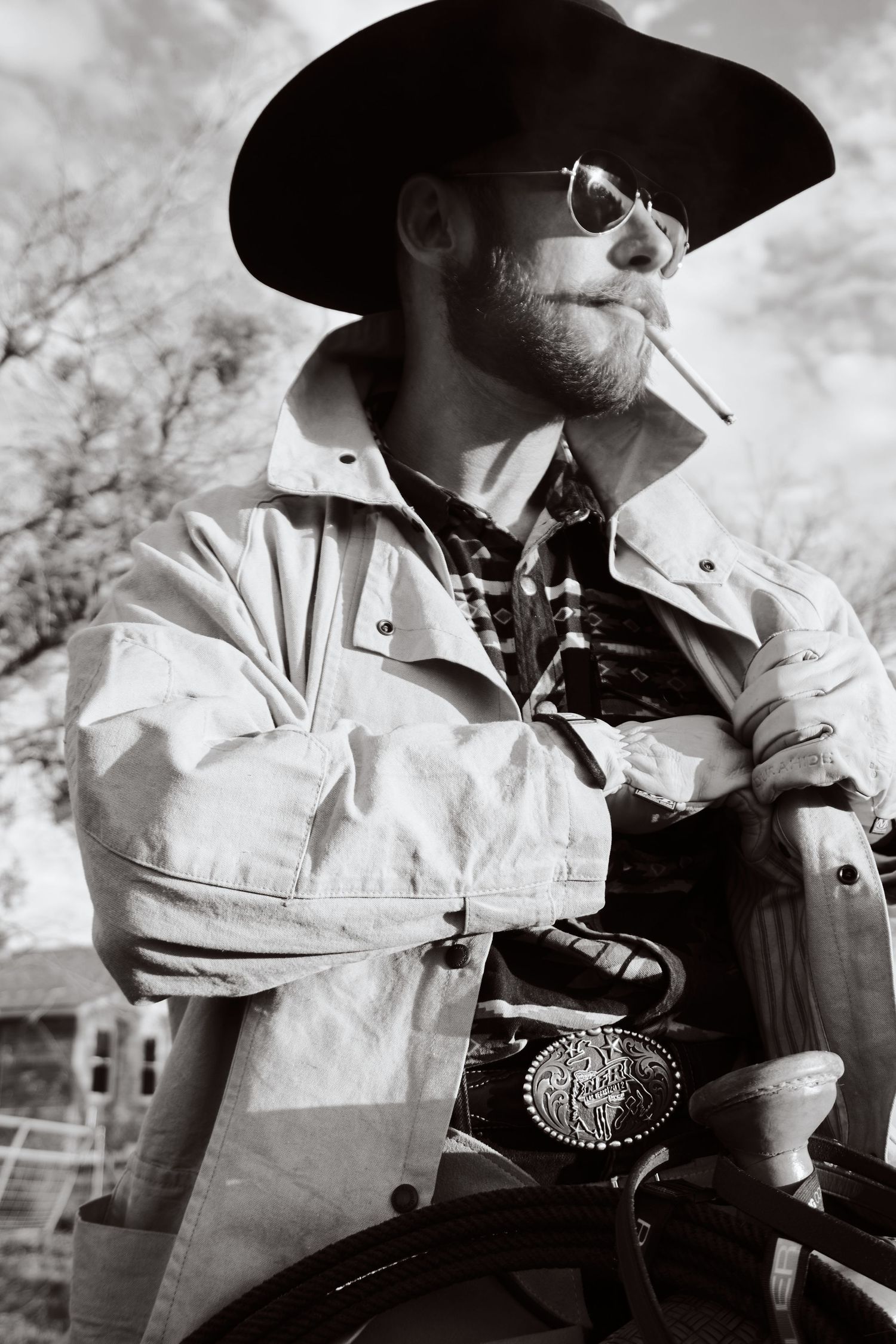 A monochrome portrait of a cowboy wearing sunglasses and a leather jacket.