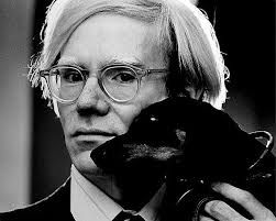 A black and white portrait with glasses holding a black cat.