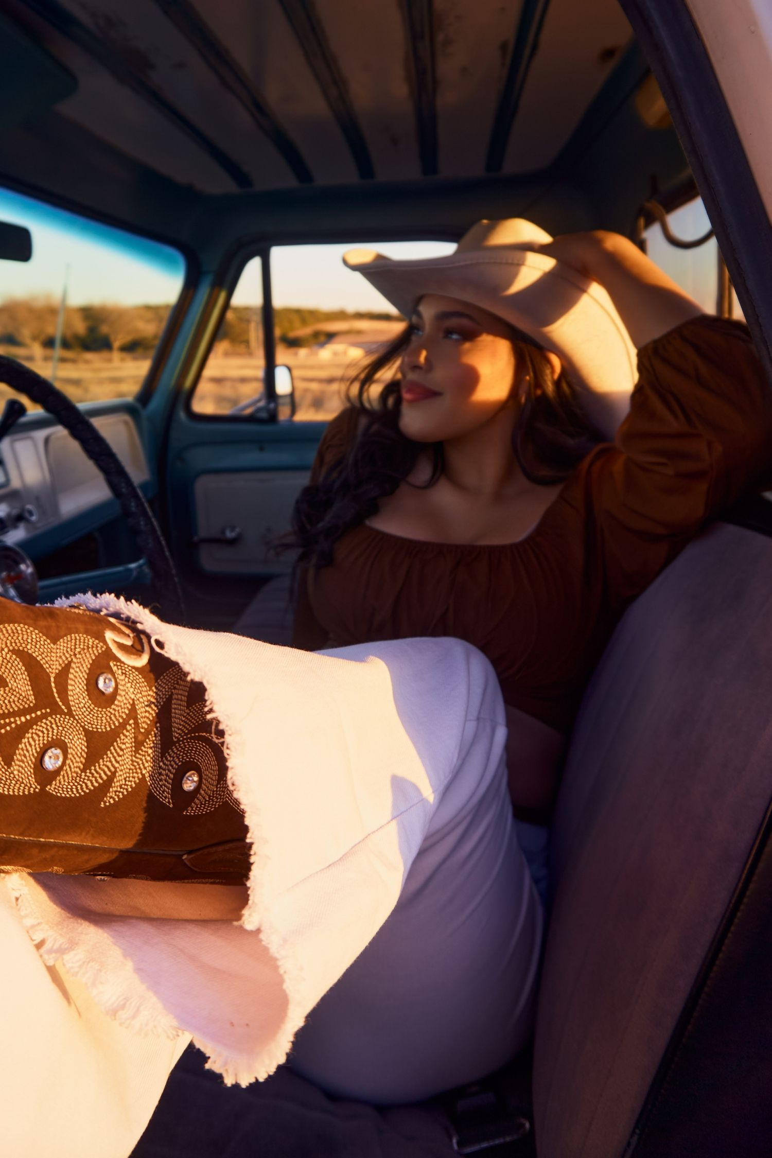 Vintage truck interior scene with western-styled clothing and decor.