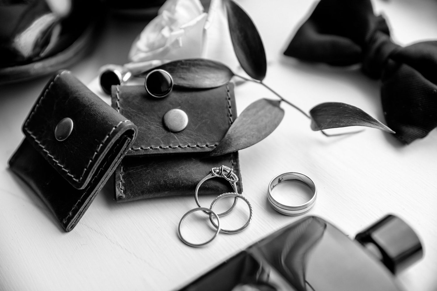 Black and white photo series showing close-up shots of luxury leather accessories and jewelry on white background.