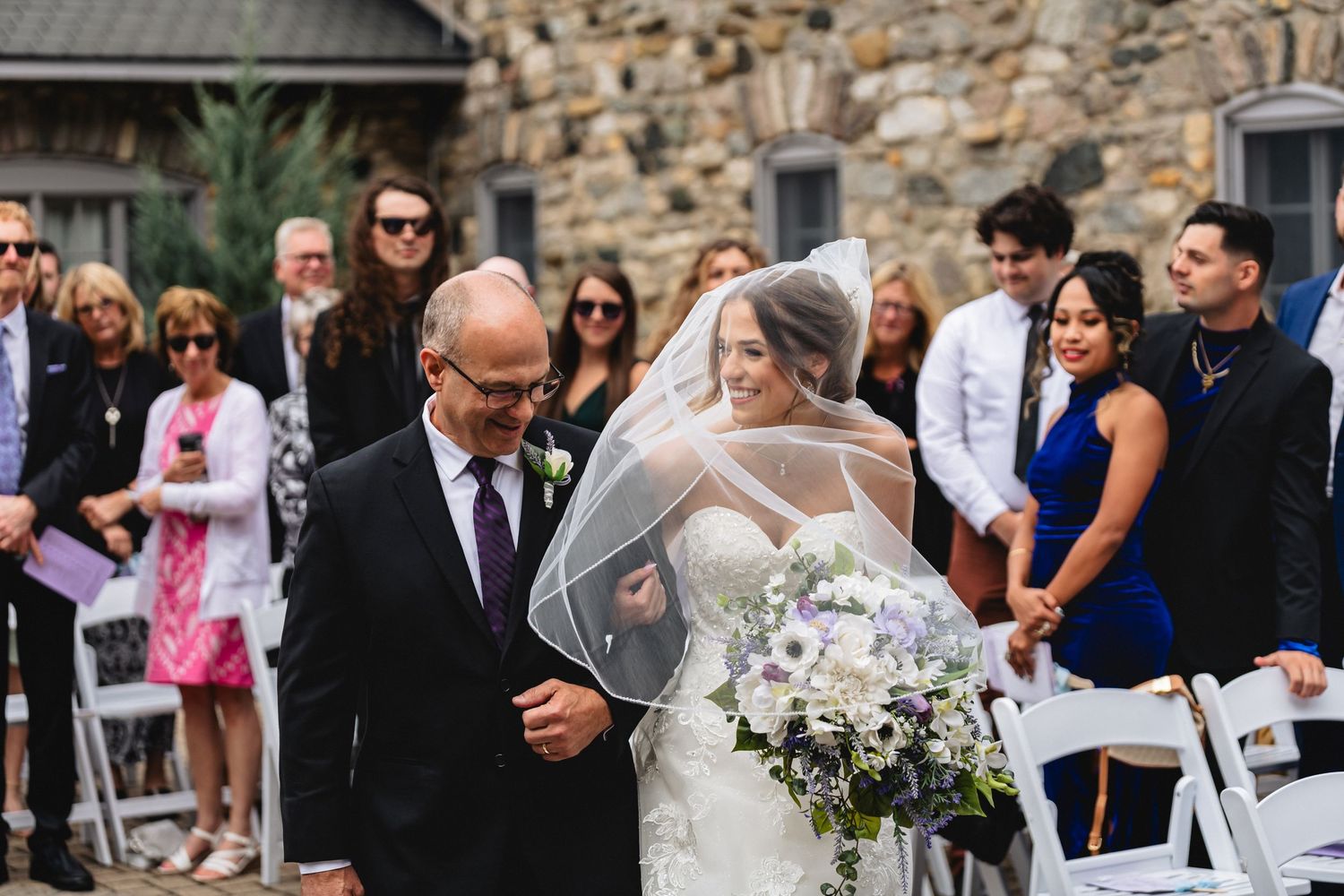 Bride smiles at her father while walking down the aisle at her Castle Farms wedding
