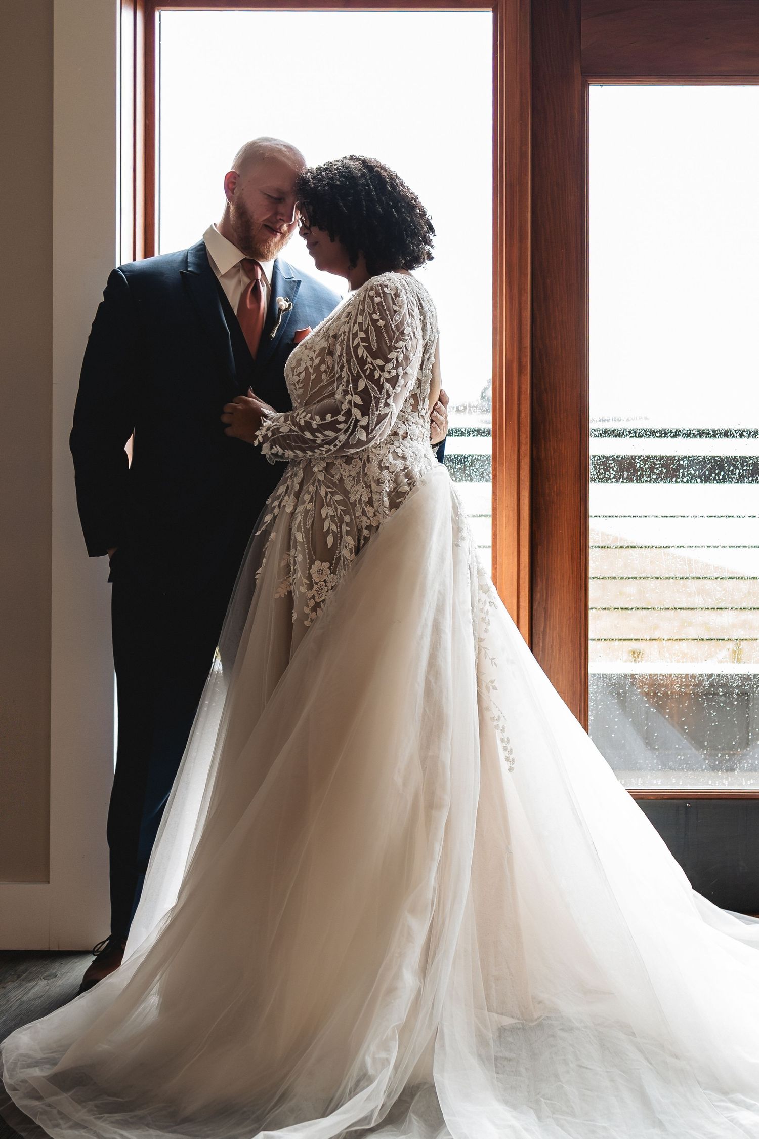 A romantic wedding scene shows a couple in formal attire sharing an intimate moment by a window.