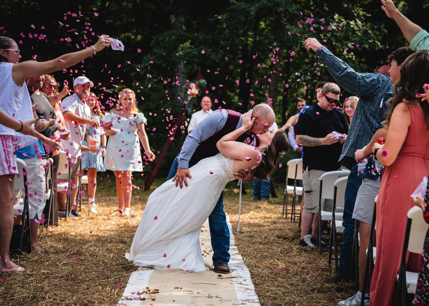 Groom dips bride for kiss during outdoor backyard wedding with confetti celebration in northern michigan