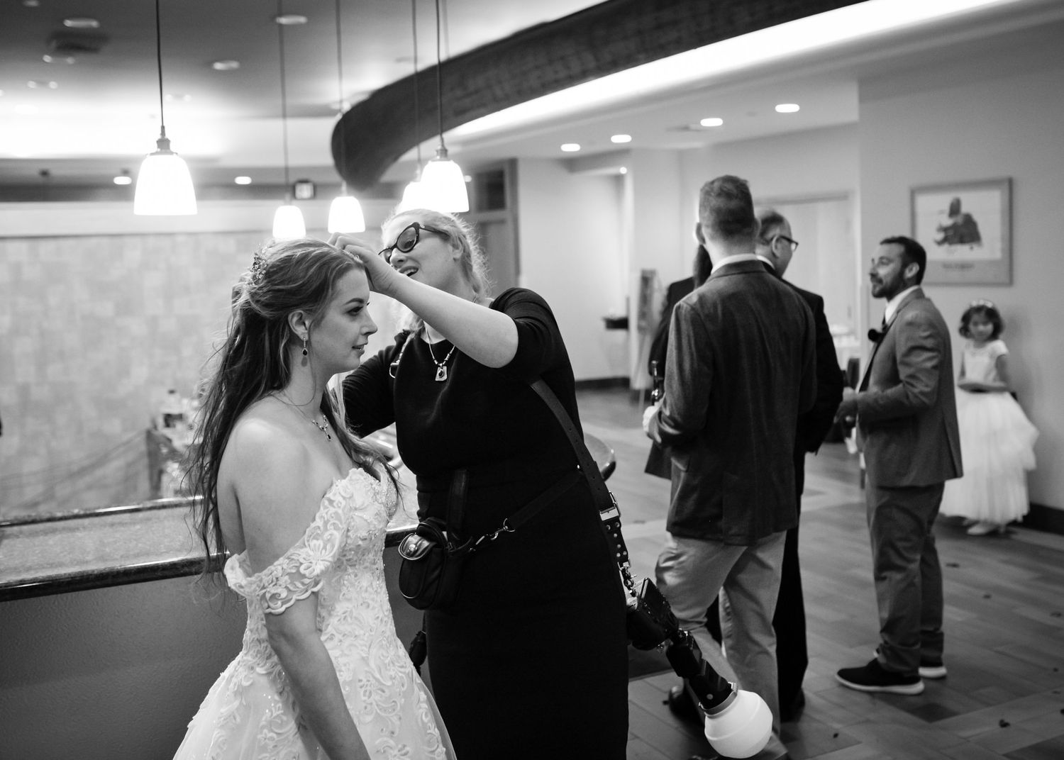 Northern Michigan wedding photographer fixes a brides hair at Crystal Mountain Resort wedding