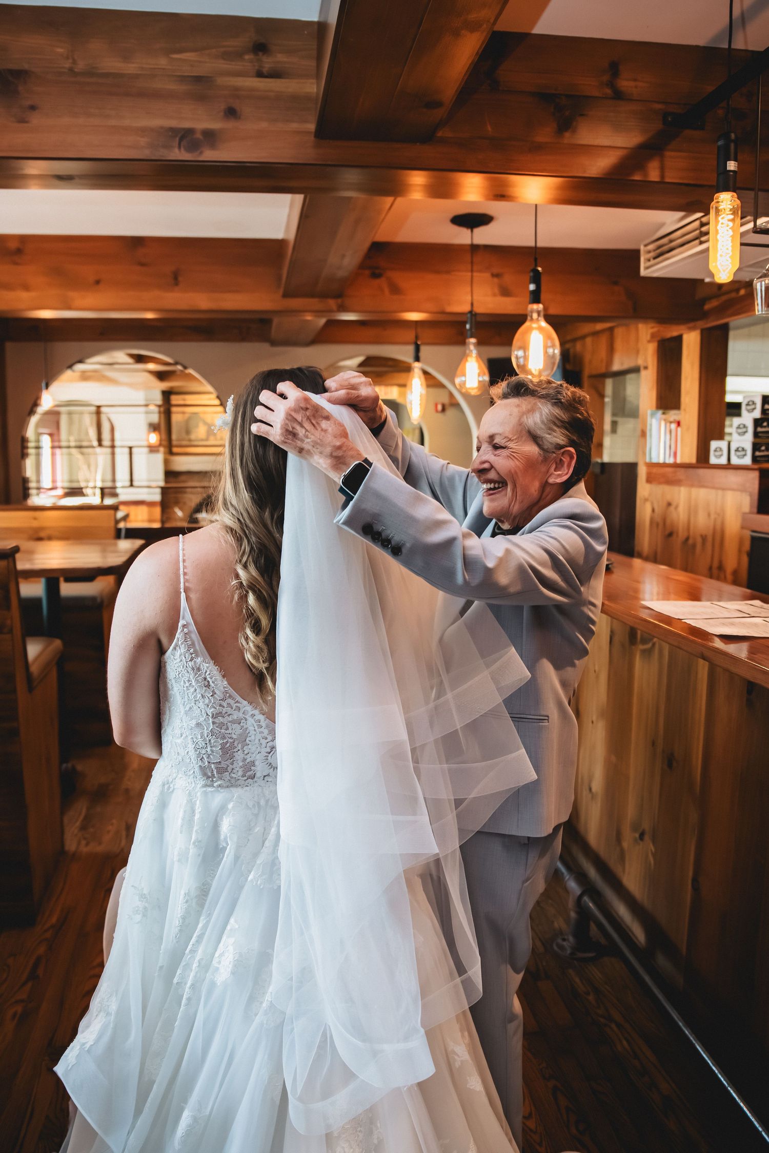 A series of emotional first look photos showing tender moments between two people in a rustic wooden venue.