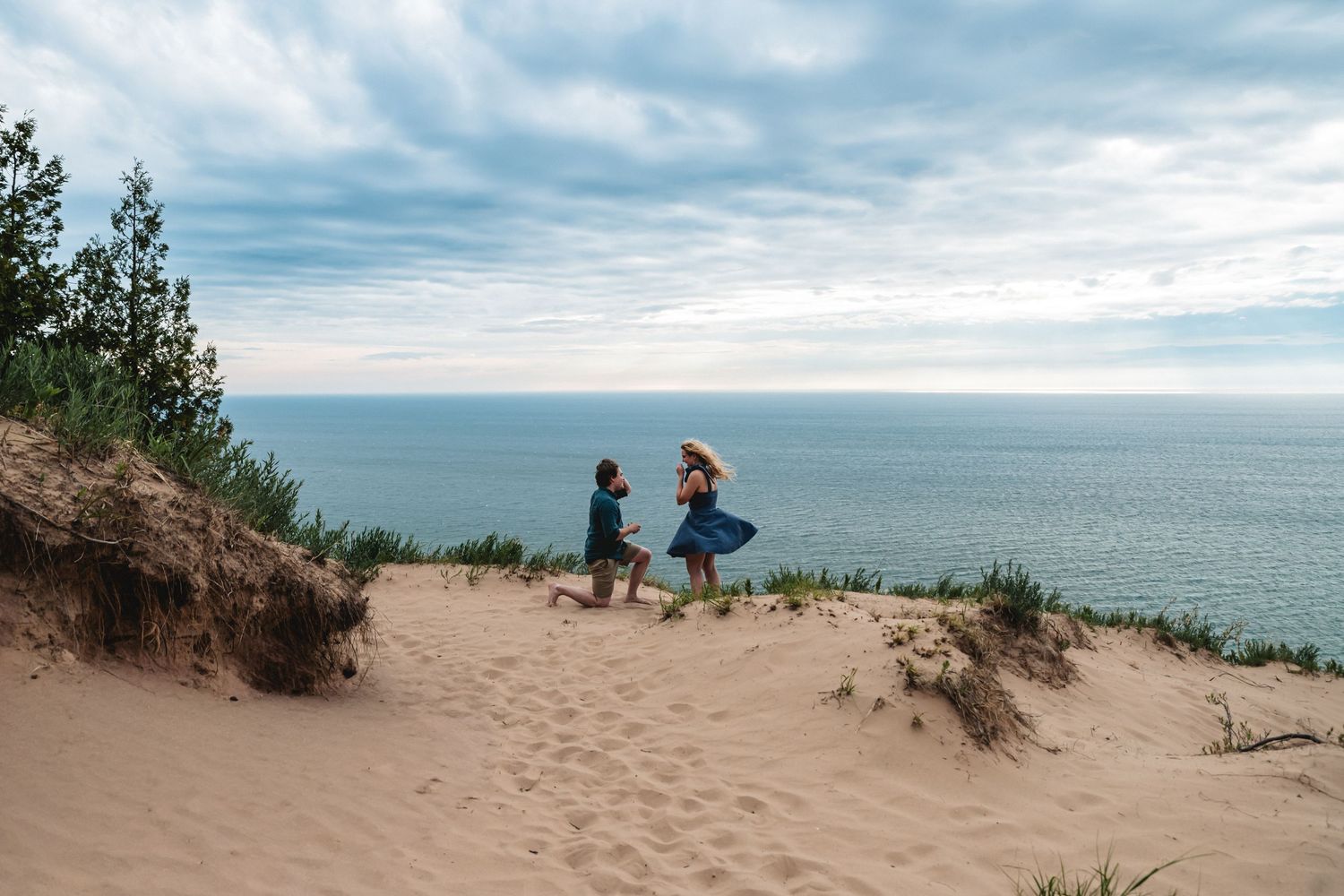 Private proposal on Sleeping Bear Dunes overlooking a serene Lake Michigan under a cloudy sky at the end of the Empire Bluff Trail.