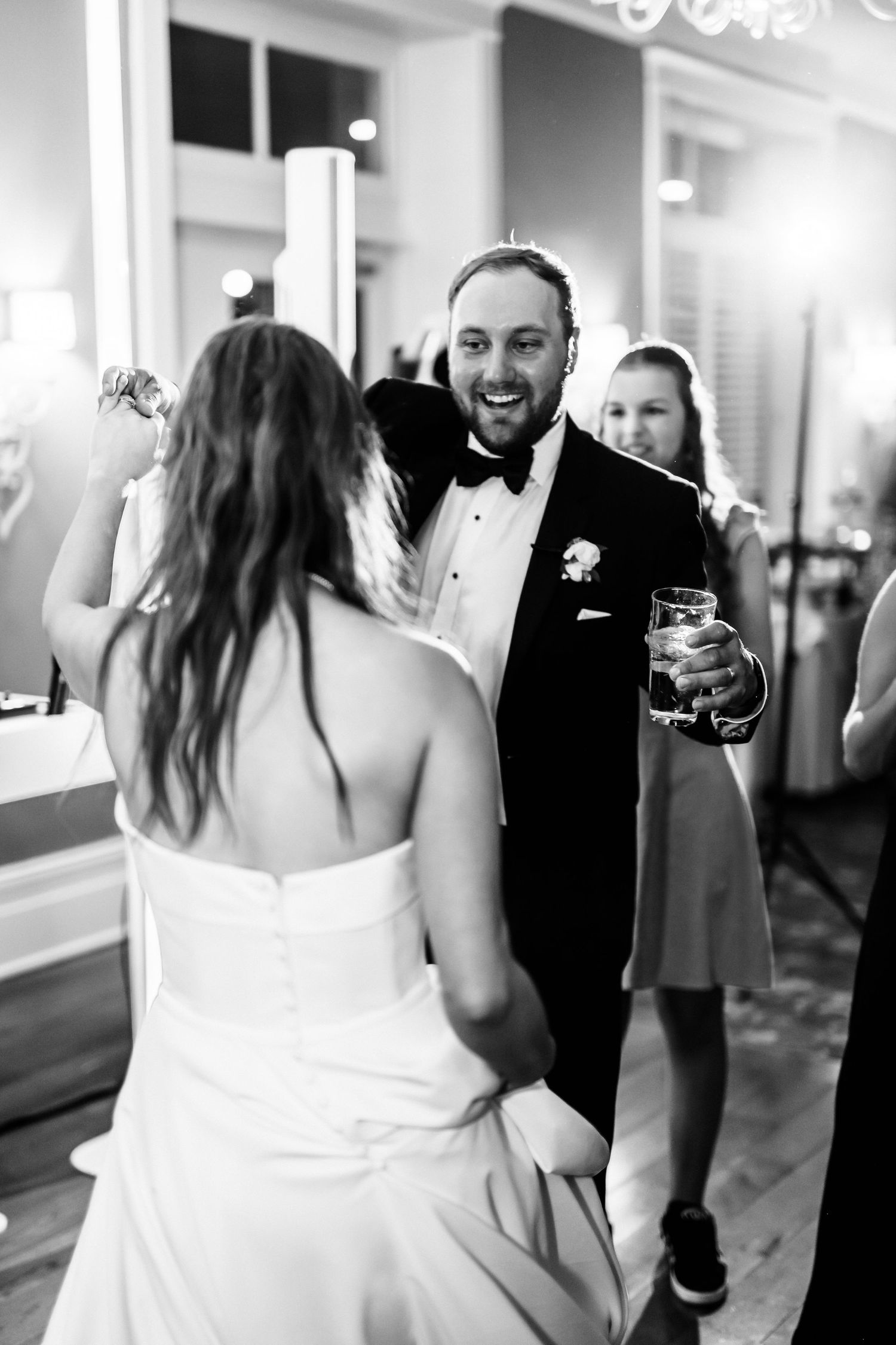 Black and white photo series showing a first look moment between a bride in white dress and groom in tuxedo.