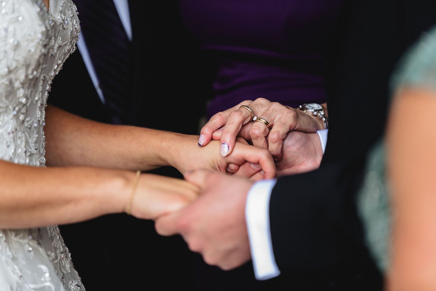Close-up of hands exchanging wedding rings during a traditional marriage ceremony.