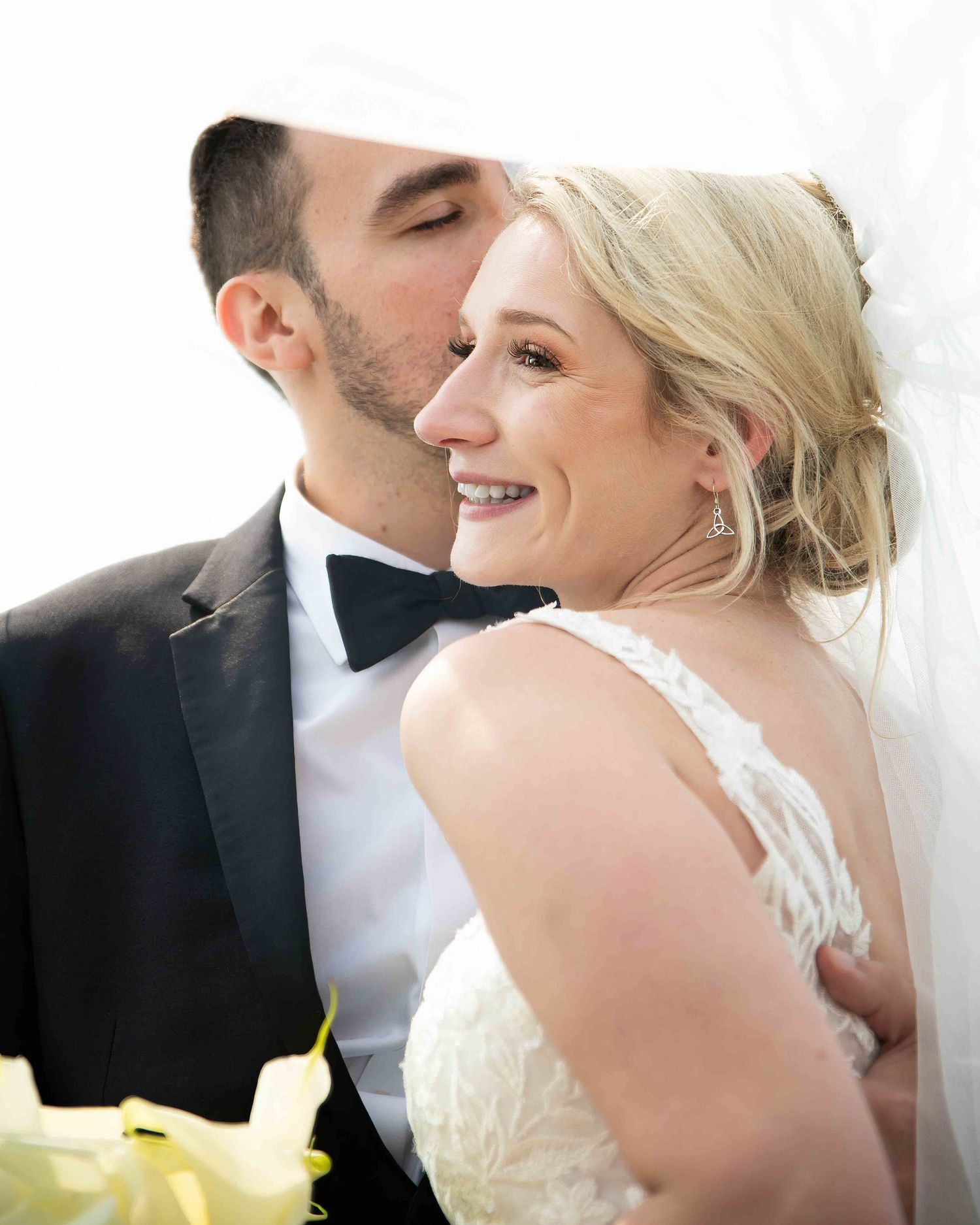 A romantic moment between newlyweds as they share an intimate kiss during their wedding photoshoot.