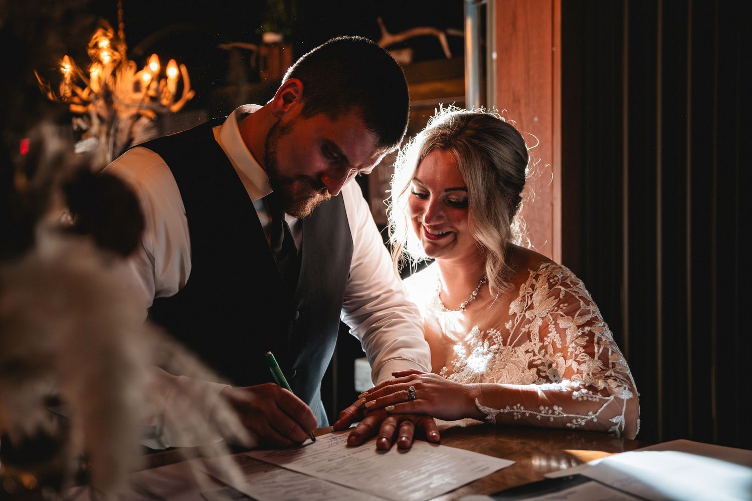 Wedding guests celebrate with sparklers during an elegant indoor reception with warm candlelight.