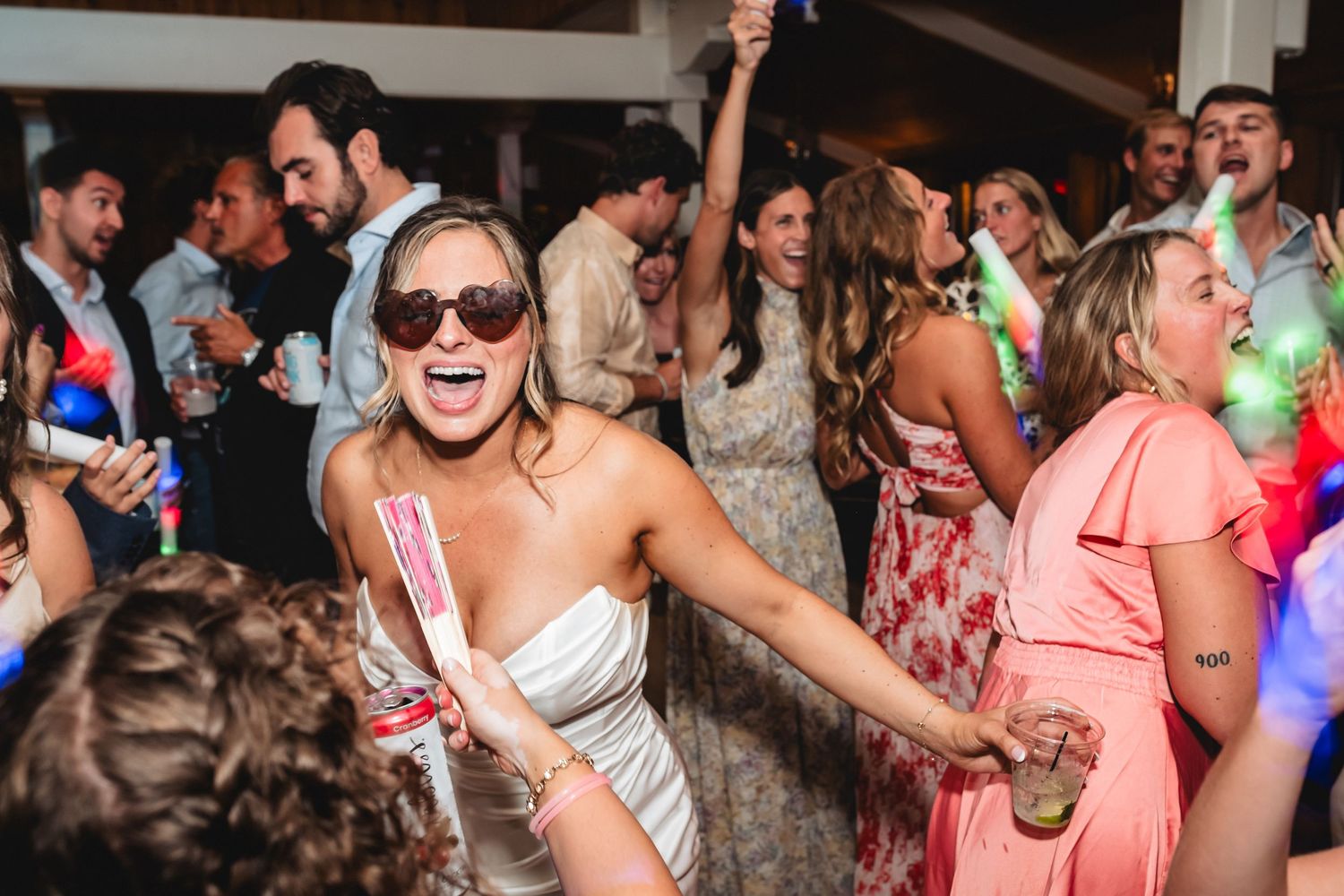A lively party scene with people dancing and celebrating in a crowded indoor venue.