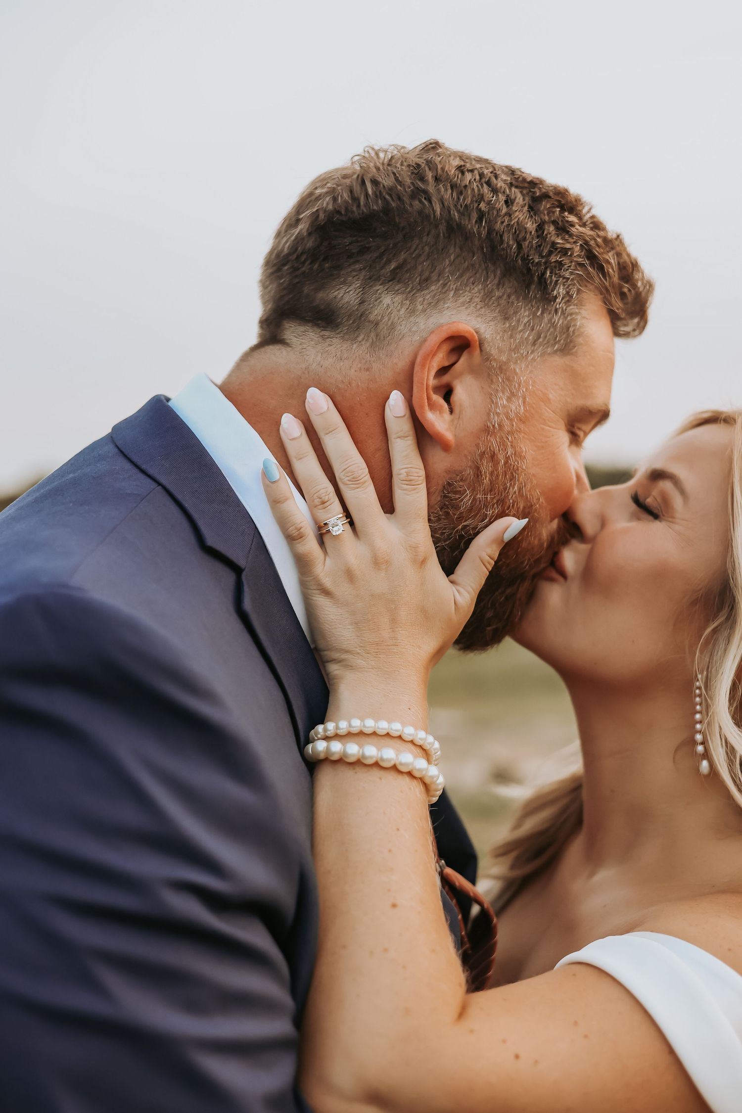 Romantic wedding portrait showing intimate kiss between newlyweds.