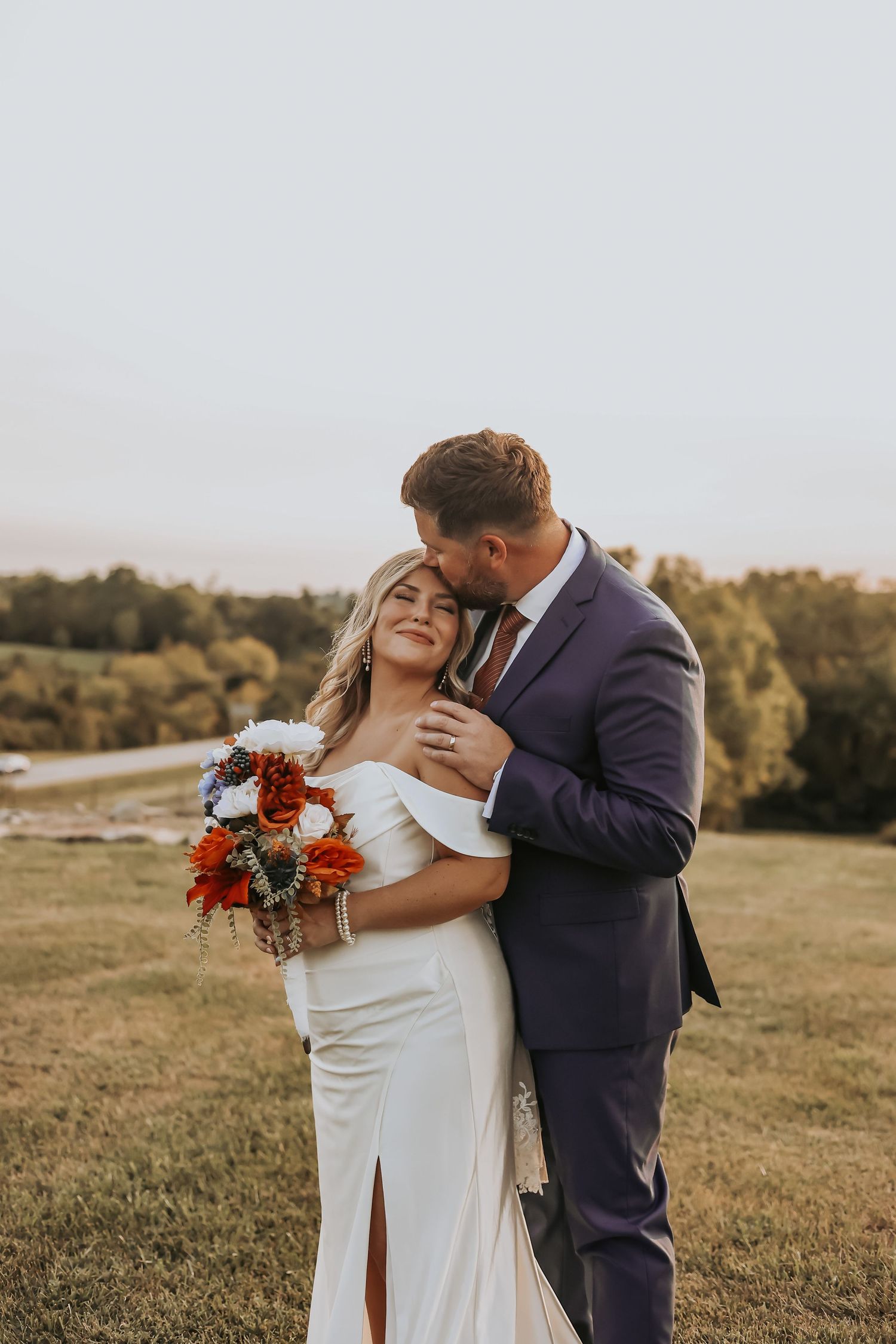 Romantic sunset moment between newlyweds in outdoor wedding setting.