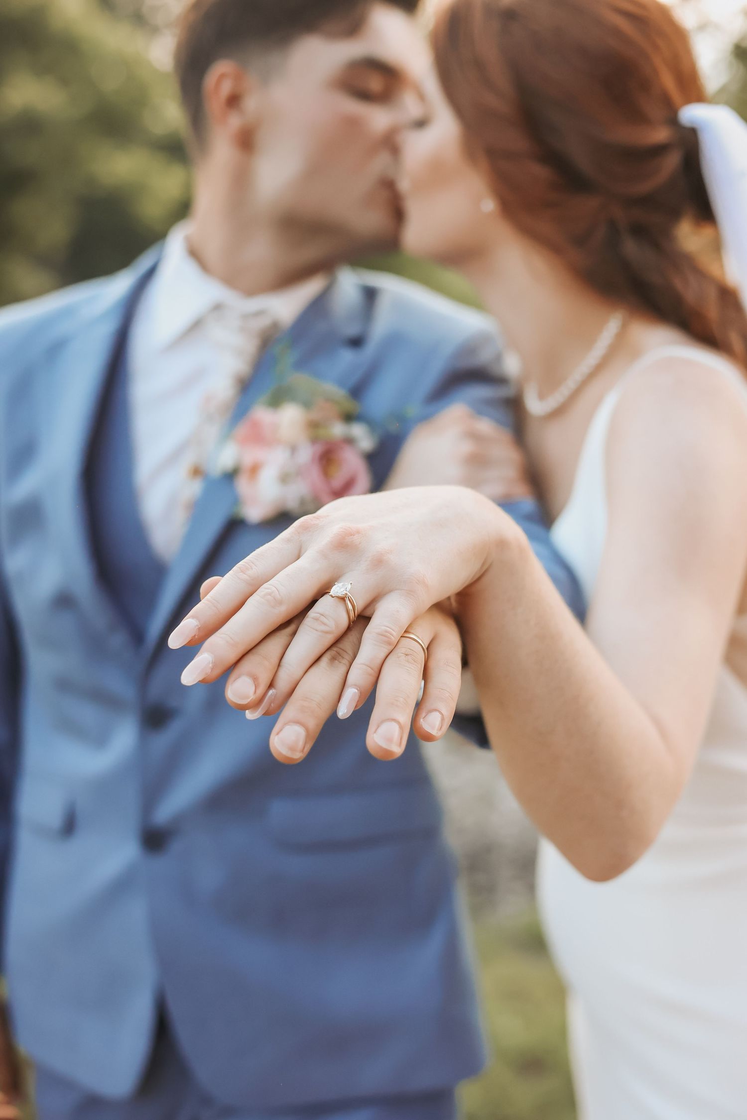 Close-up of wedding rings and hands while couple shares intimate moment.