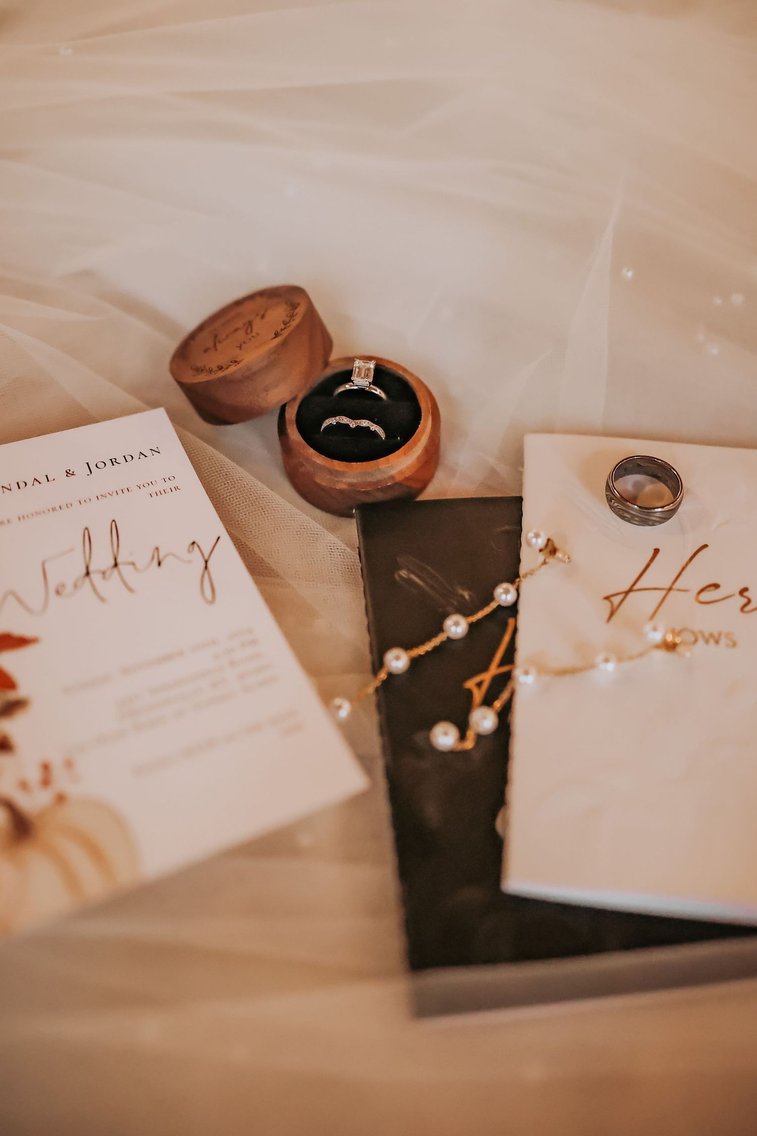 Wedding vow books and engagement ring in a wooden box with romantic decor.