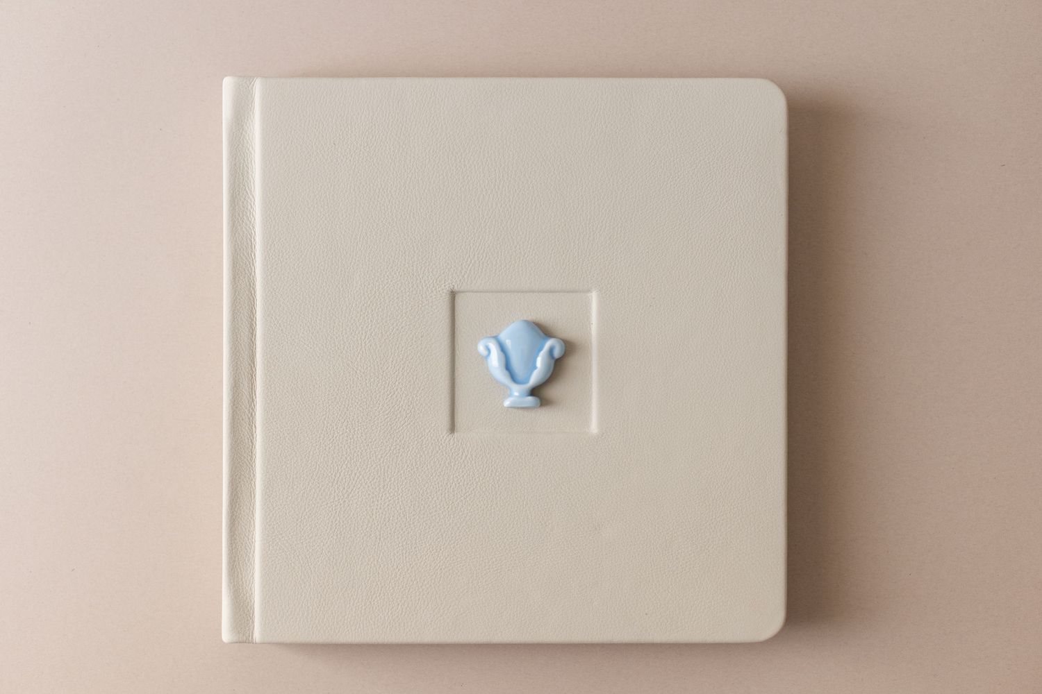 Elegant white teacups and saucers arranged on light colored books creating a minimalist aesthetic composition.
