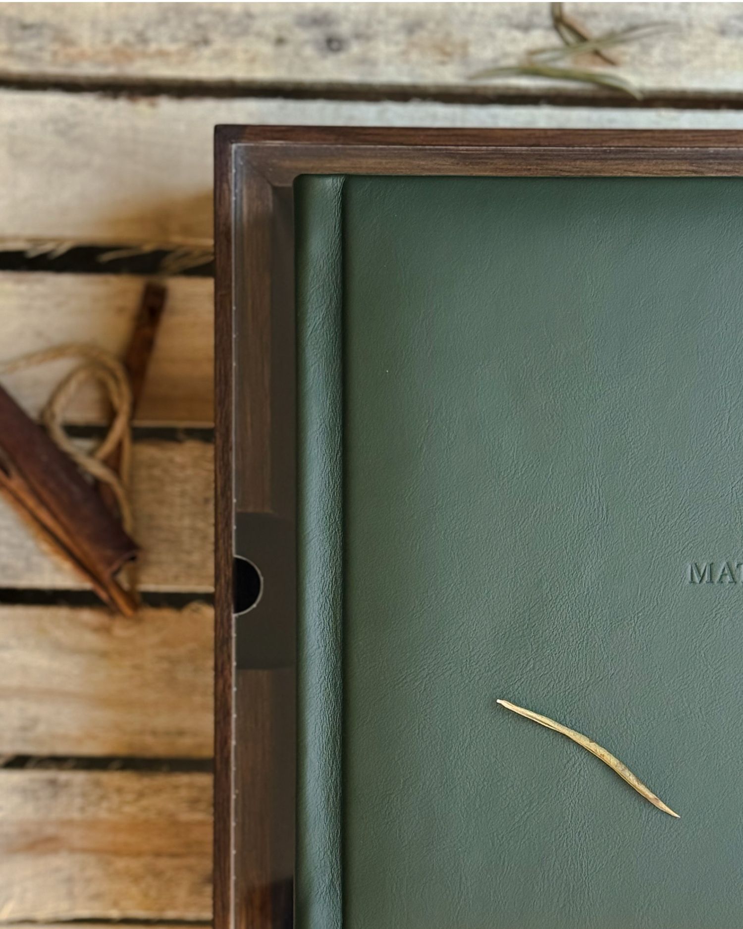 Close-up of a green leather album cover with wooden accents.