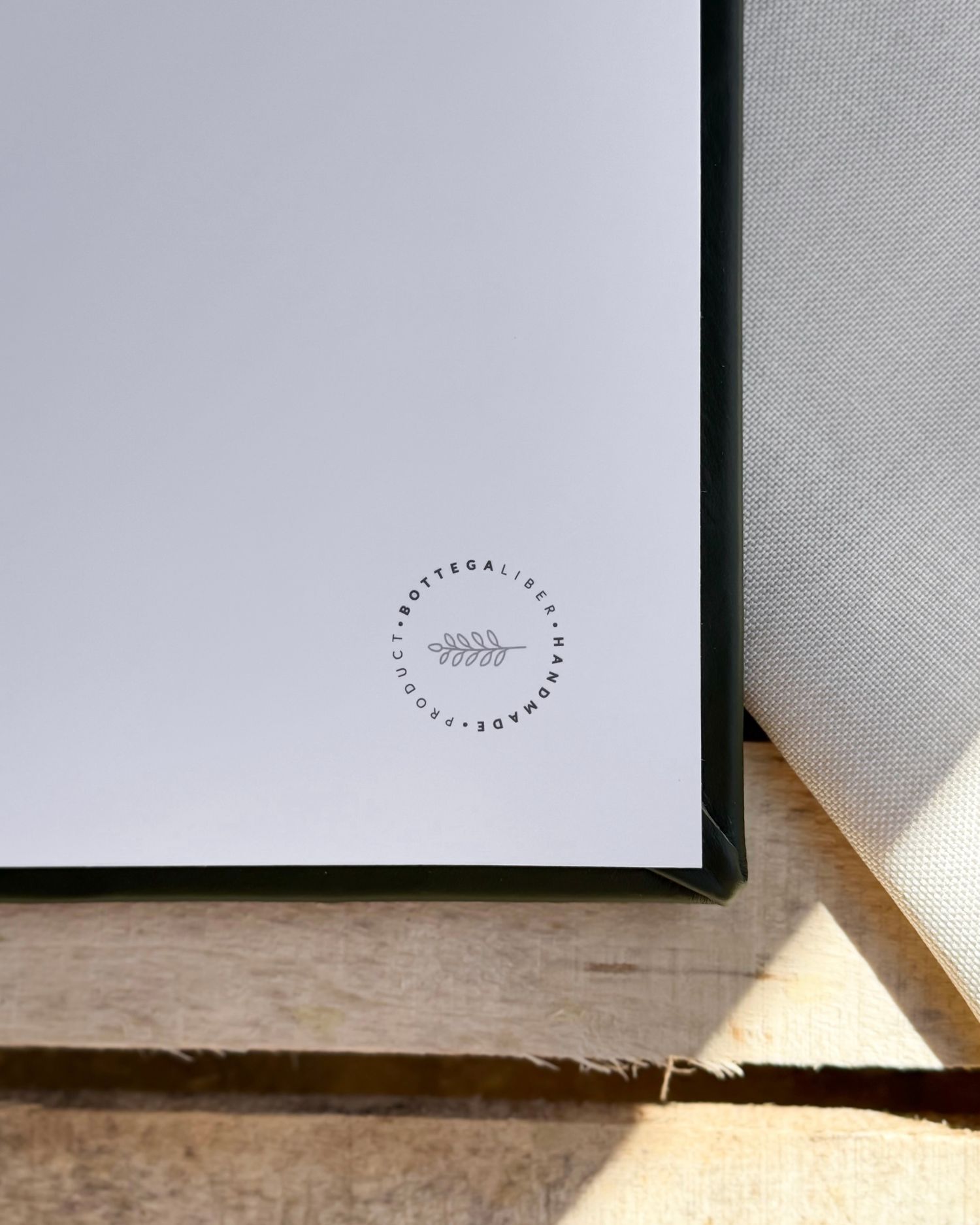 Minimalist white paper with subtle logo design casting soft shadows.