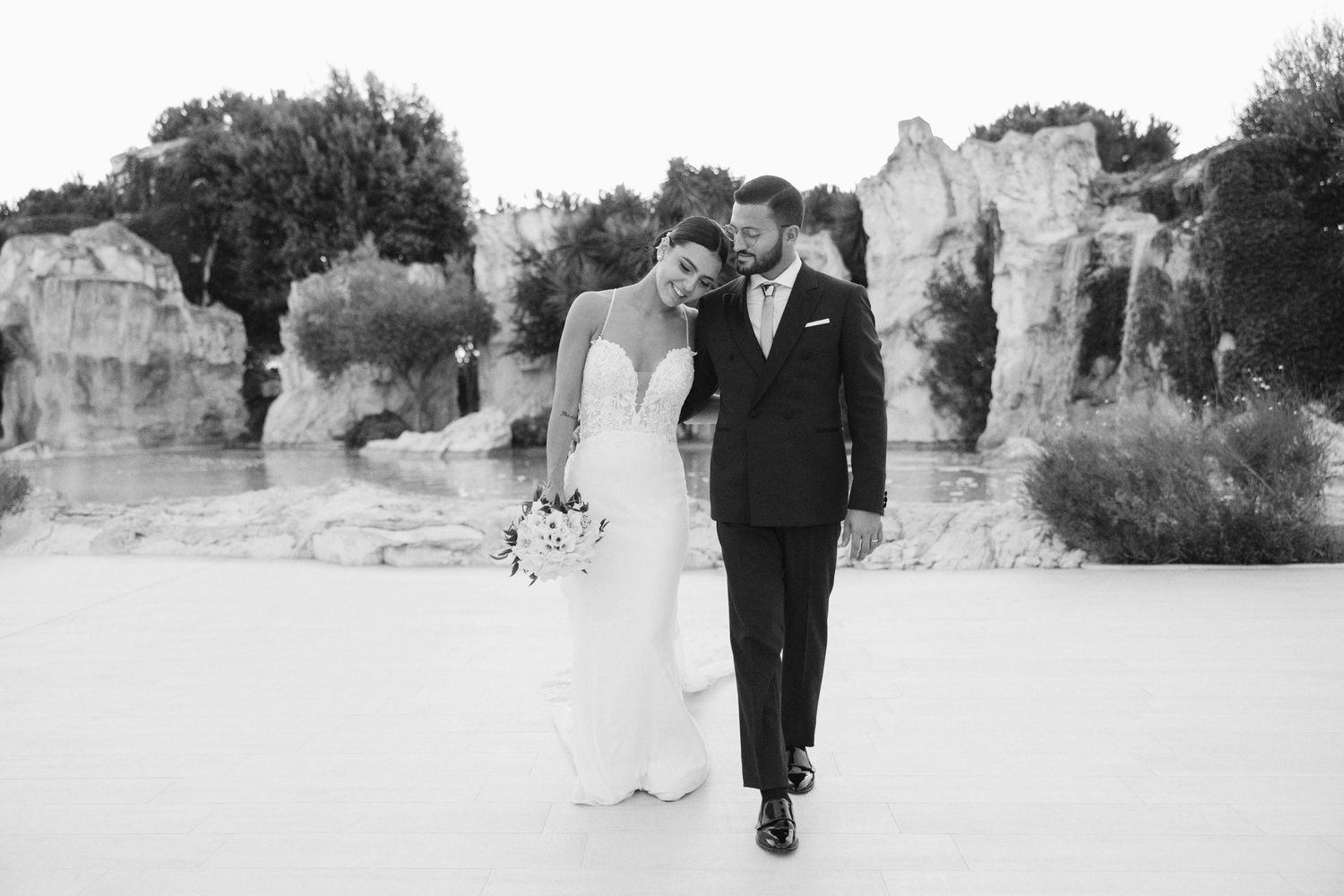 Black and white wedding photography capturing romantic moments in a Mediterranean landscape.