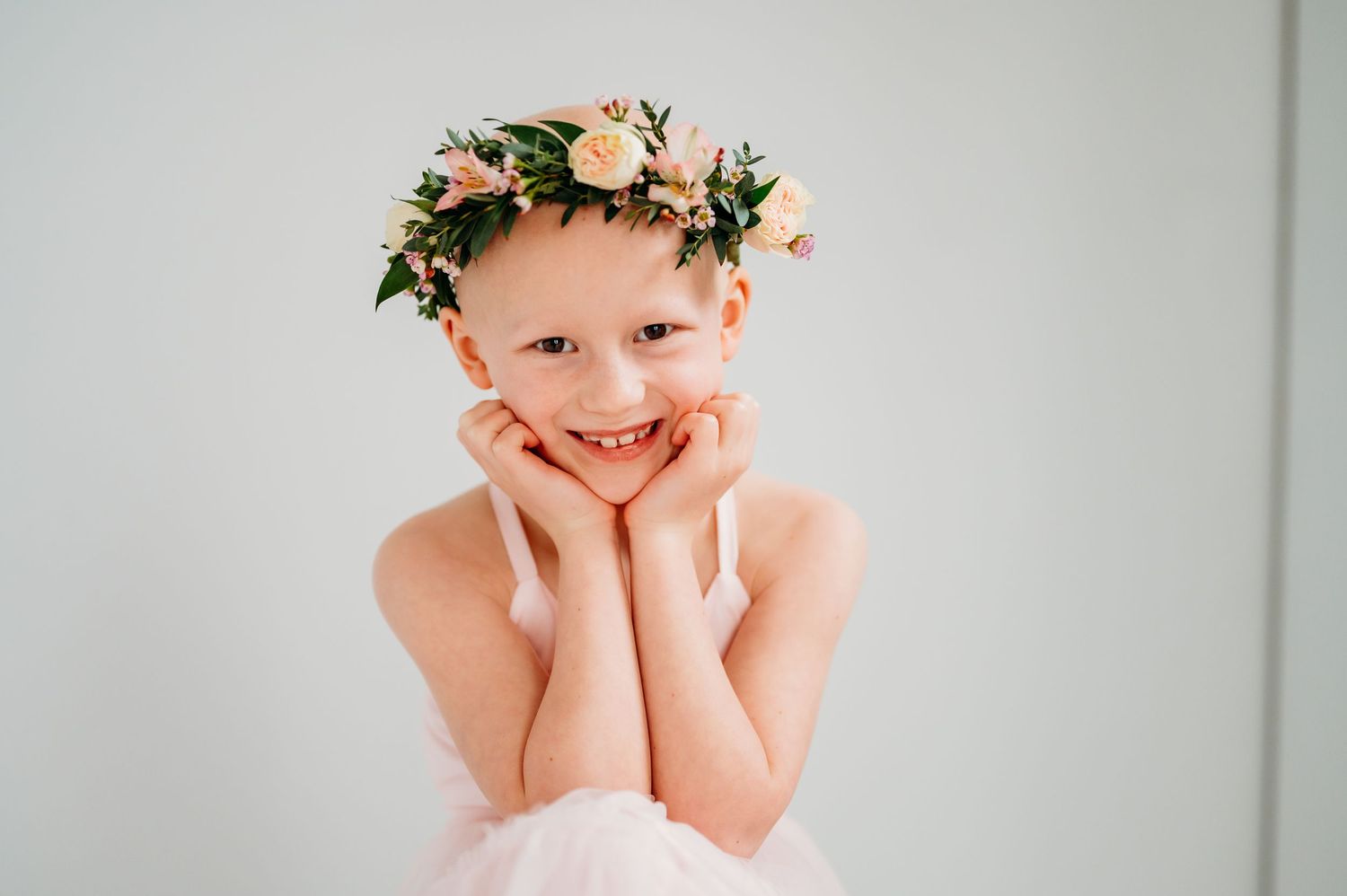 A series of four connected portraits showing someone wearing a floral crown against a light background.