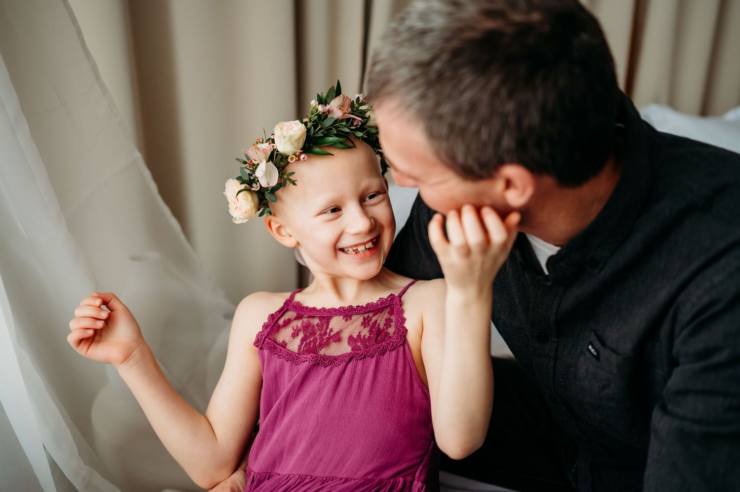 A loving family moment captured in black and white as a father shares tender interactions with his daughter in a purple dress.