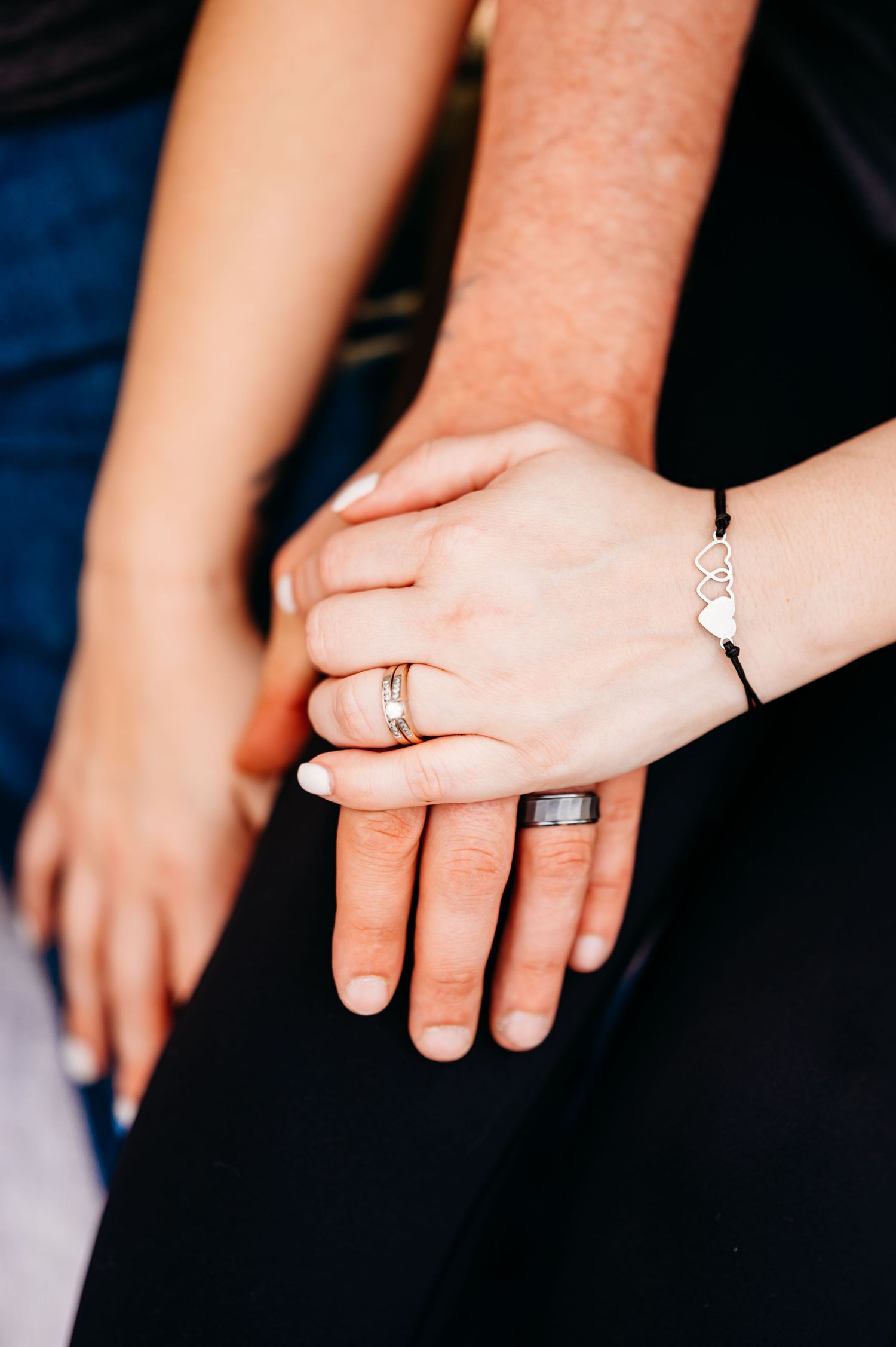 Close-up sequence showing engagement ring being placed on finger against dark blue background.