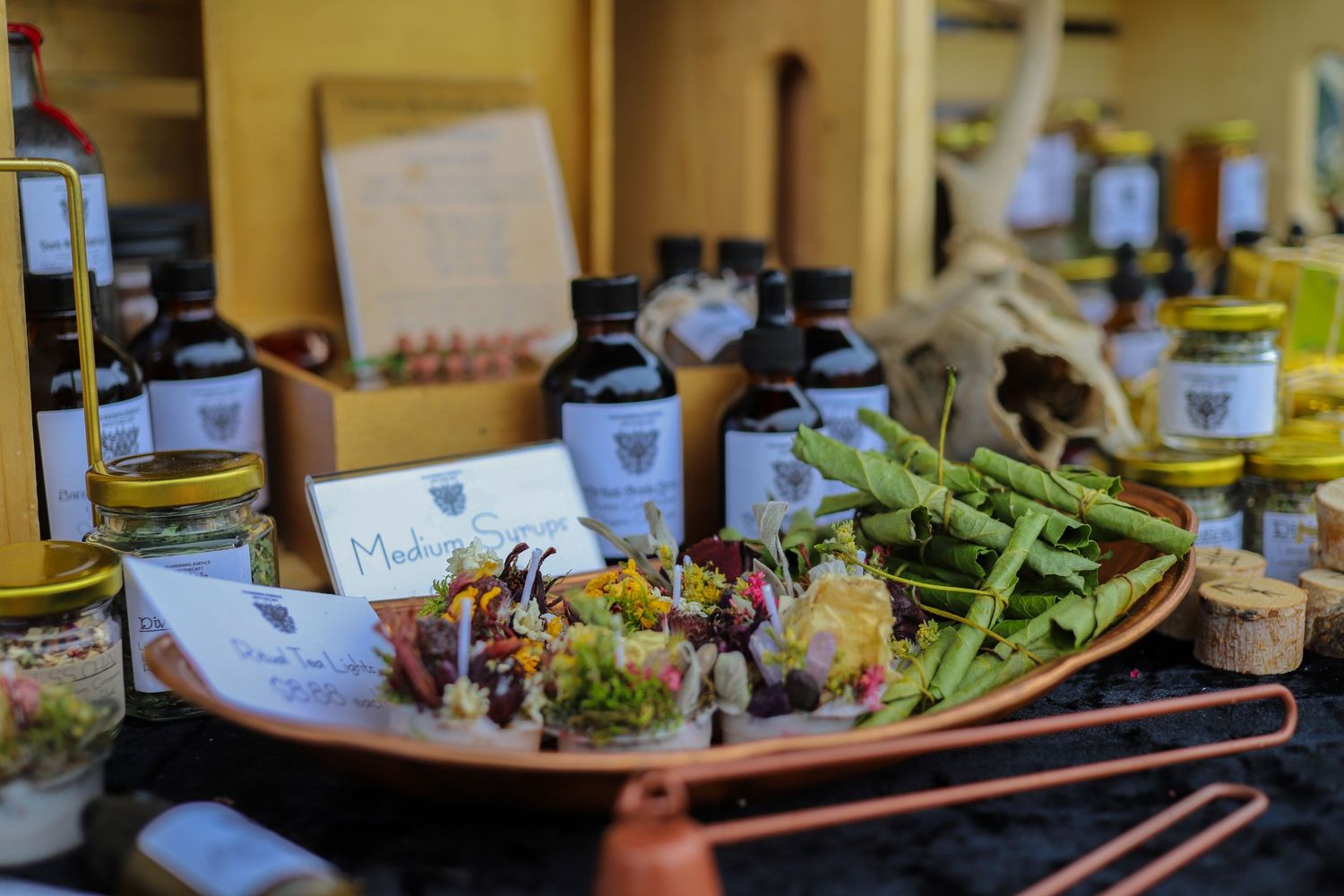 Artisan market display featuring fresh vegetables, herbal products, and gourmet food items.