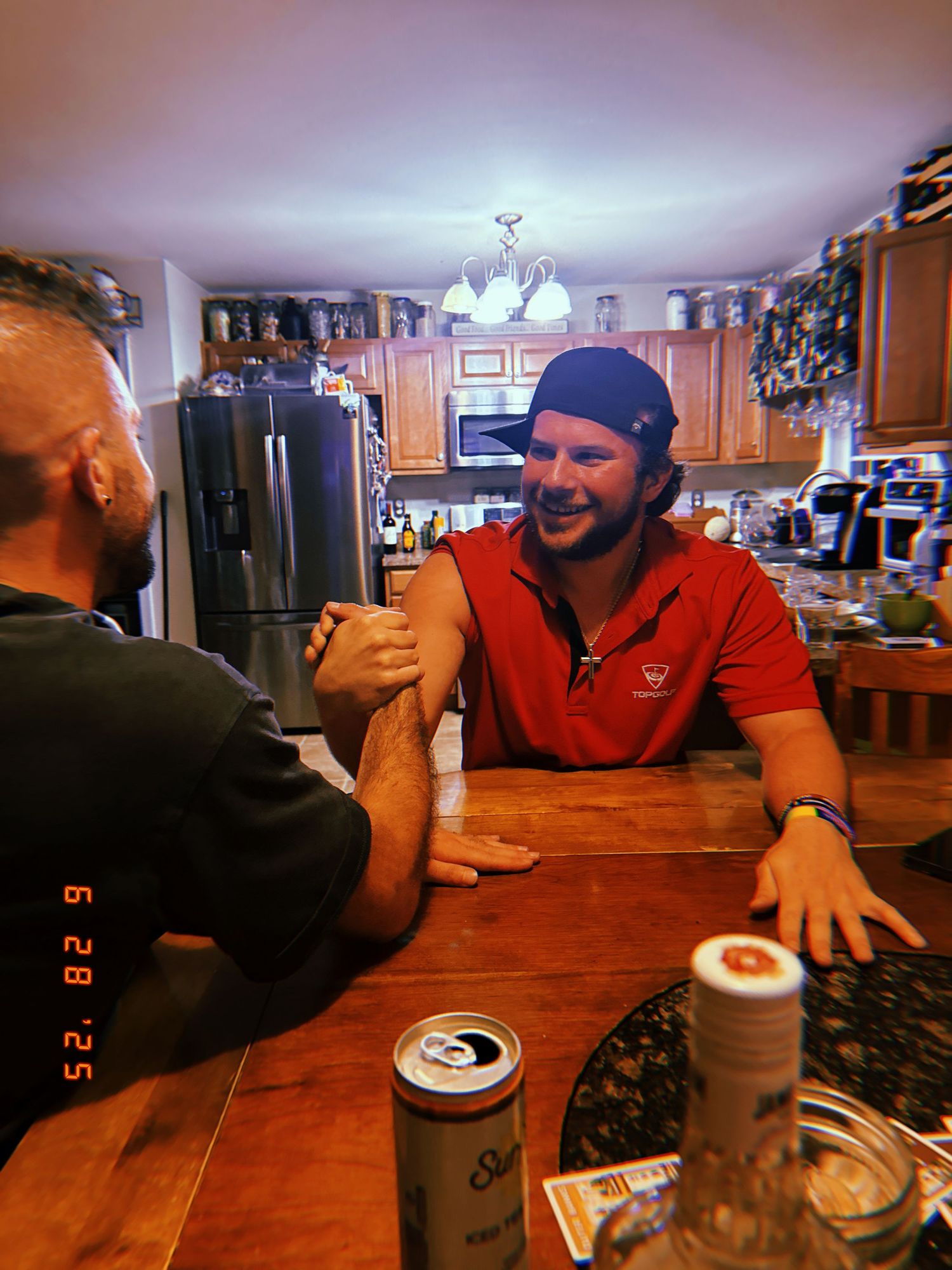 People gathered around a wooden dining table having a conversation in a cozy home setting.