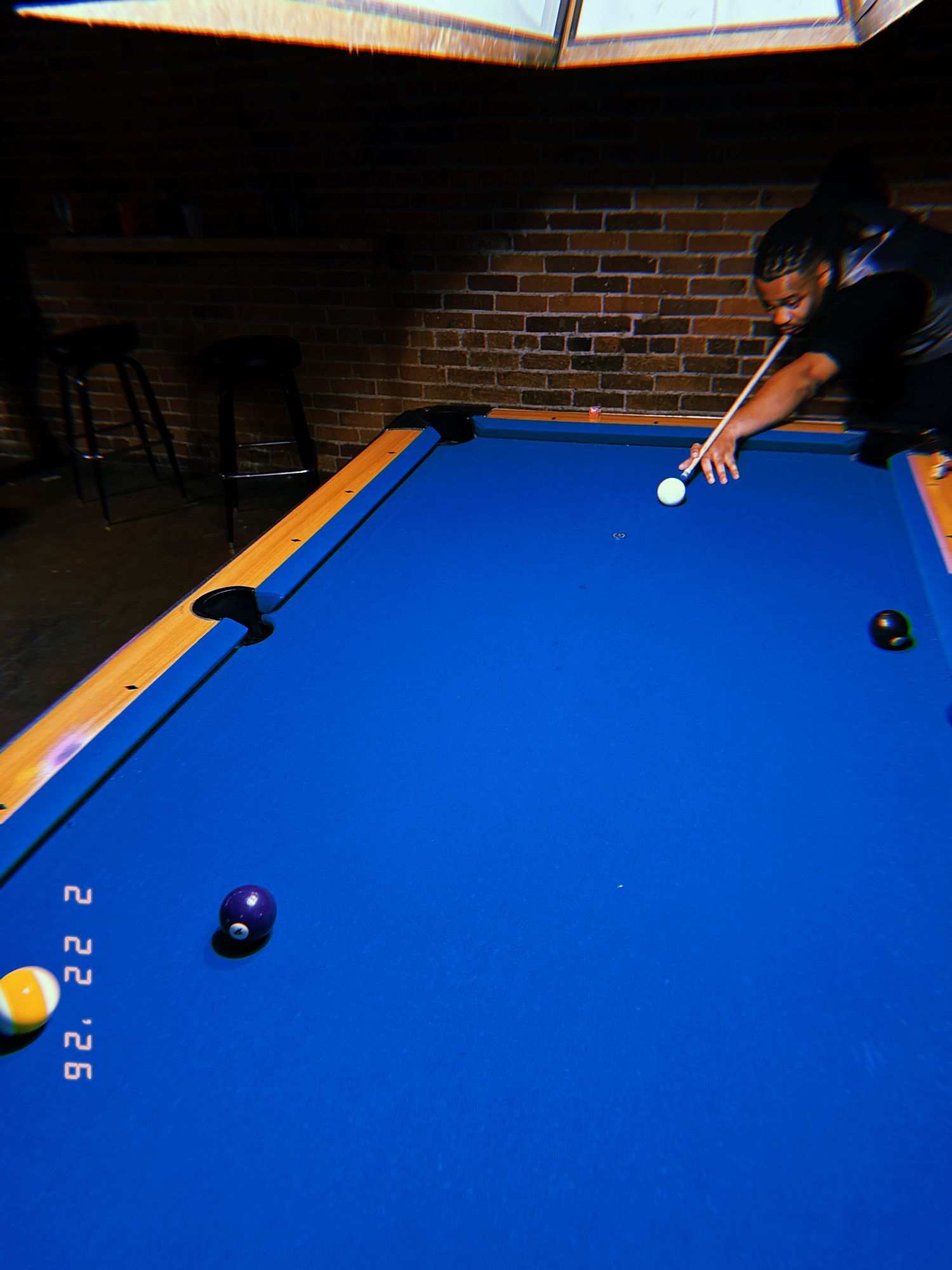 A sequence of pool shots showing a player lining up and executing billiards shots on a bright blue felt table.