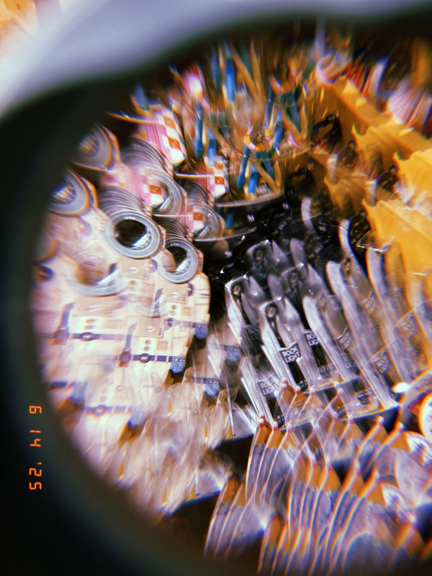 Close-up kaleidoscopic view with distorted patterns showing blues, oranges and purples through a circular lens.