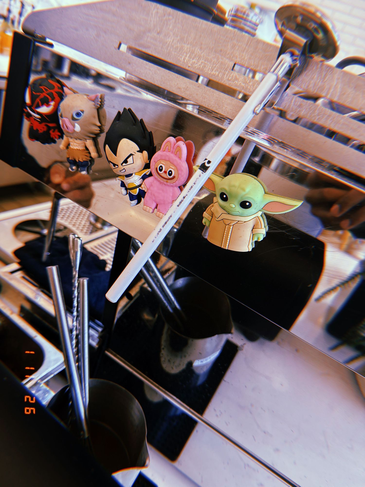 A collection of Baby Yoda Funko Pop figures displayed on a desk with office supplies in the background.