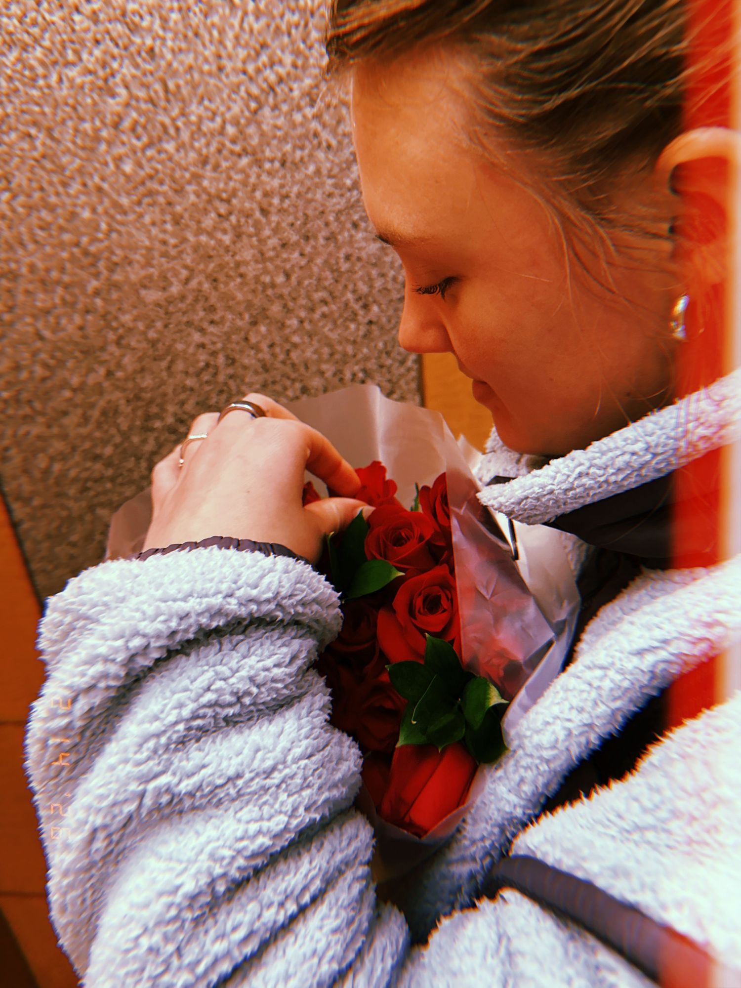 A sequence of photos showing someone in a white towel smelling a red rose with increasing closeness.